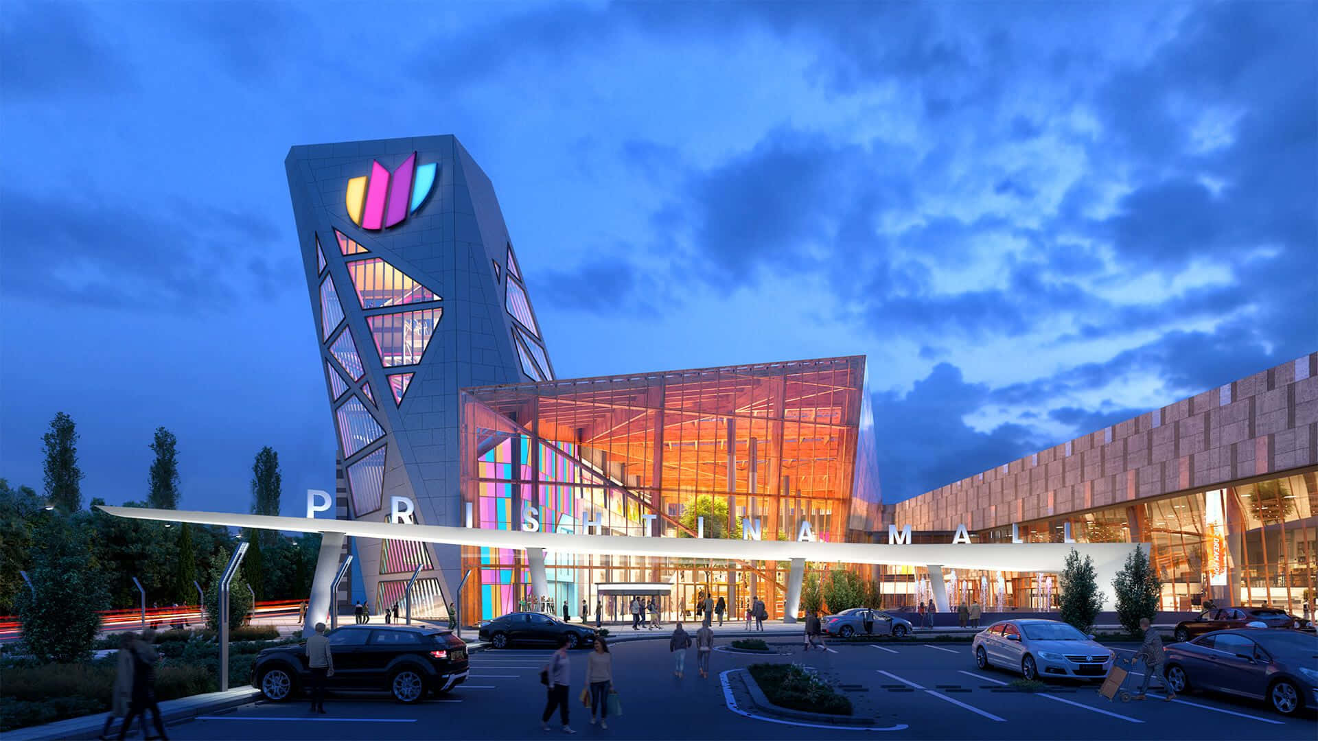 Mall 桌布 壁紙 — 一個現代購物中心，擁有色彩繽紛的幾何塔樓和發光的玻璃外牆，在暮色天空下。