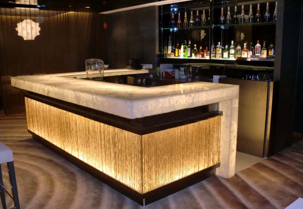Bar 桌布 壁紙 — 一個現代酒吧，帶有發光的竹製底座和大理石檯面，周圍環繞著擺滿酒瓶的架子。