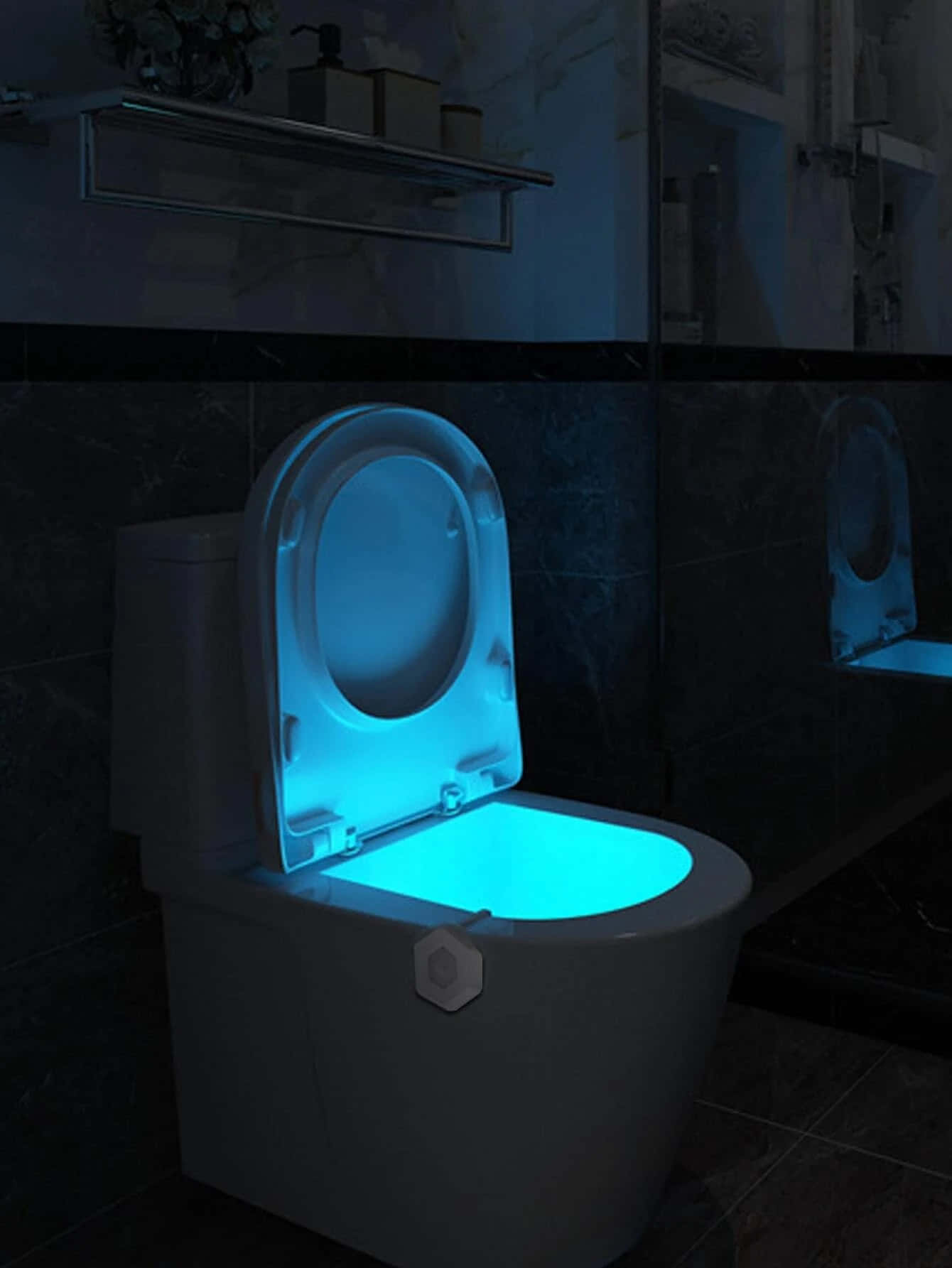 Toilet 桌布 壁紙 — 一個現代馬桶在昏暗的浴室中發出冷藍色環境光，背景是深色瓷磚牆和鏡櫃。