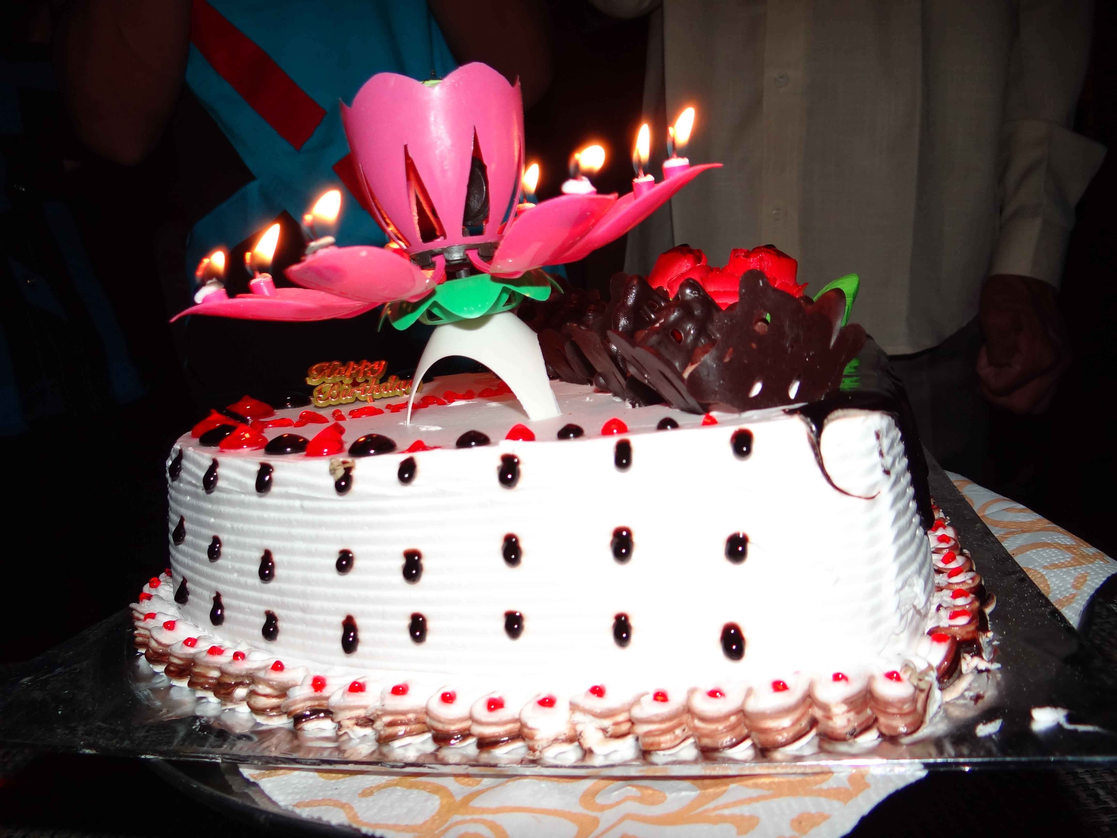 Birthday 桌布 壁紙 — 一個生日蛋糕，配有白色糖霜、巧克力醬和櫻桃配料，上面放有粉紅色蓮花燭台和點燃的蠟燭。