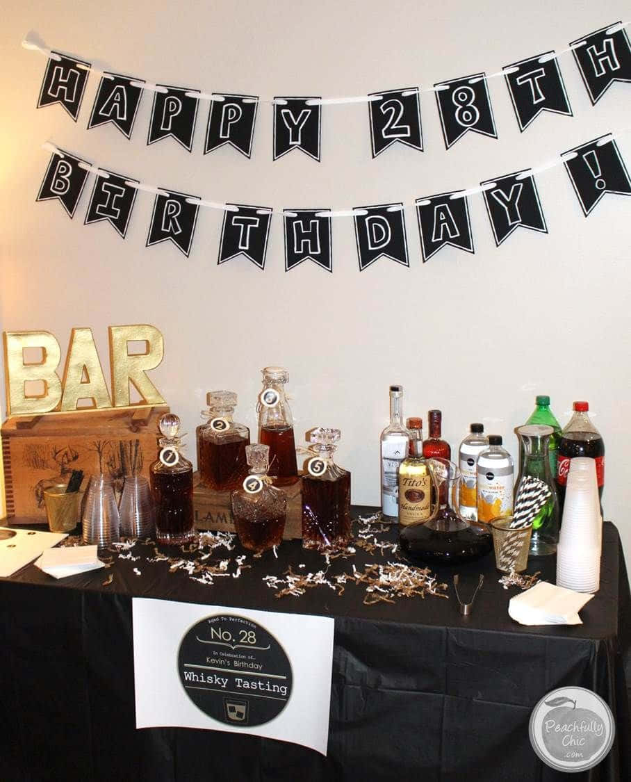 Birthday Party 桌布 壁紙 — 一個生日酒吧設置，有威士忌酒瓶、酒杯和一個寫著「28歲生日快樂」的橫幅。