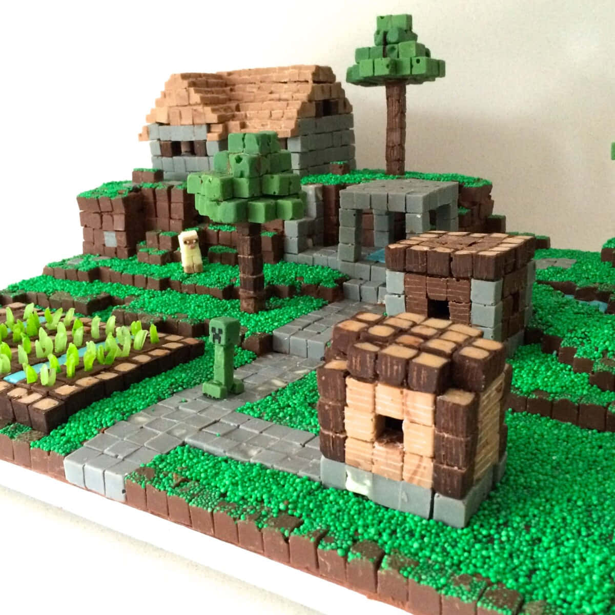 Minecraft Cakes 桌布 壁紙 — 一個用巧克力方塊建造的詳細Minecraft村莊，綠色糖粒作為草地，還有可食用的樹木。