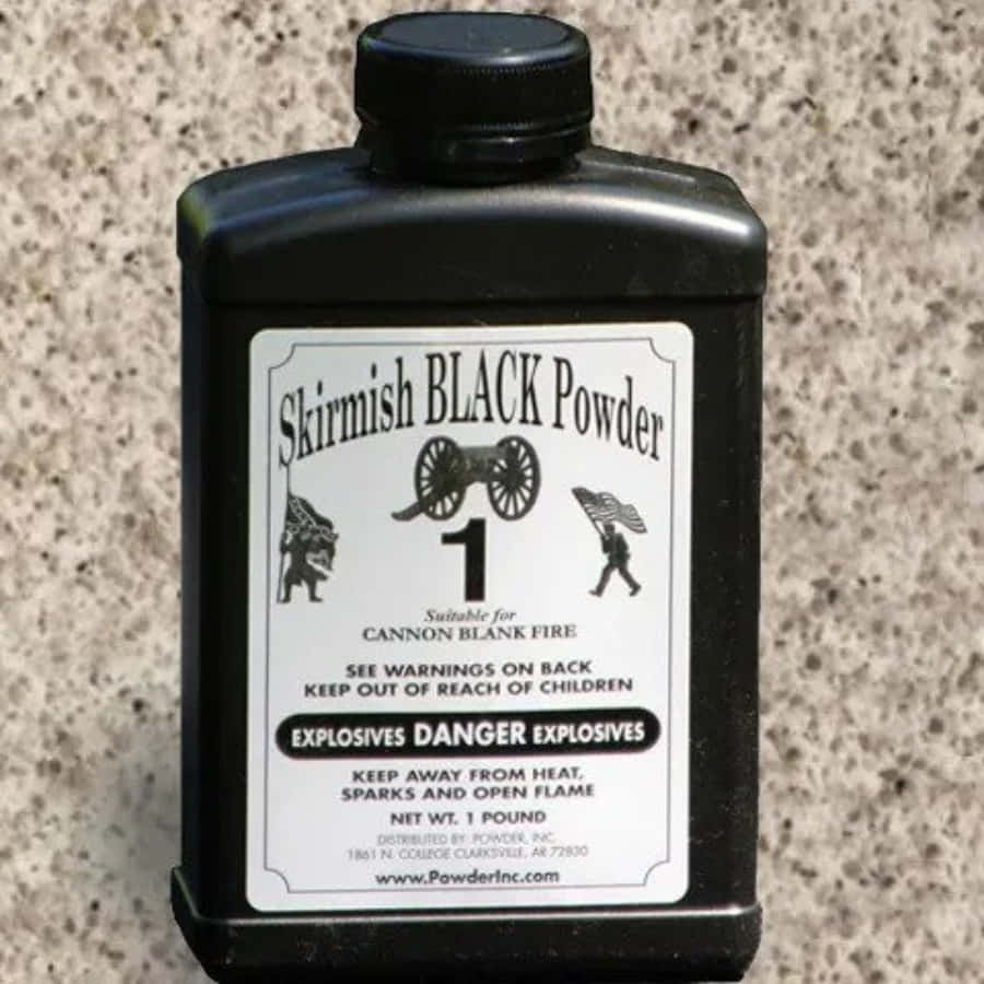Black Powder 桌布 壁紙 — 一個用於大炮空包彈射擊的Skirmish Black Powder黑色塑膠容器，放置在斑點檯面上。