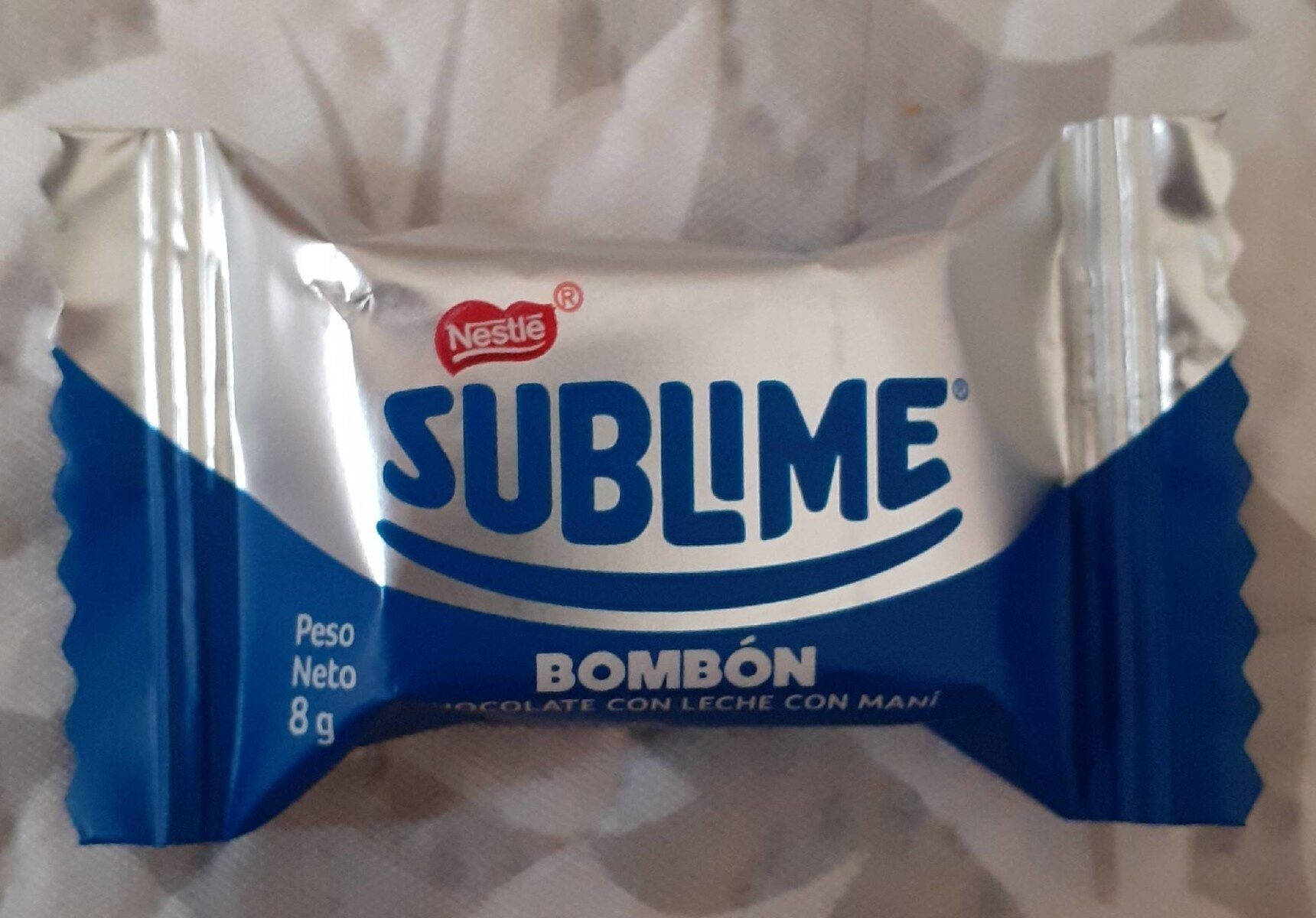 Chocolate 桌布 壁紙 — 一個用藍色和銀色箔紙包裹的Nestlé Sublime牛奶巧克力bombón，放在皺巴巴的白色表面上，特寫。