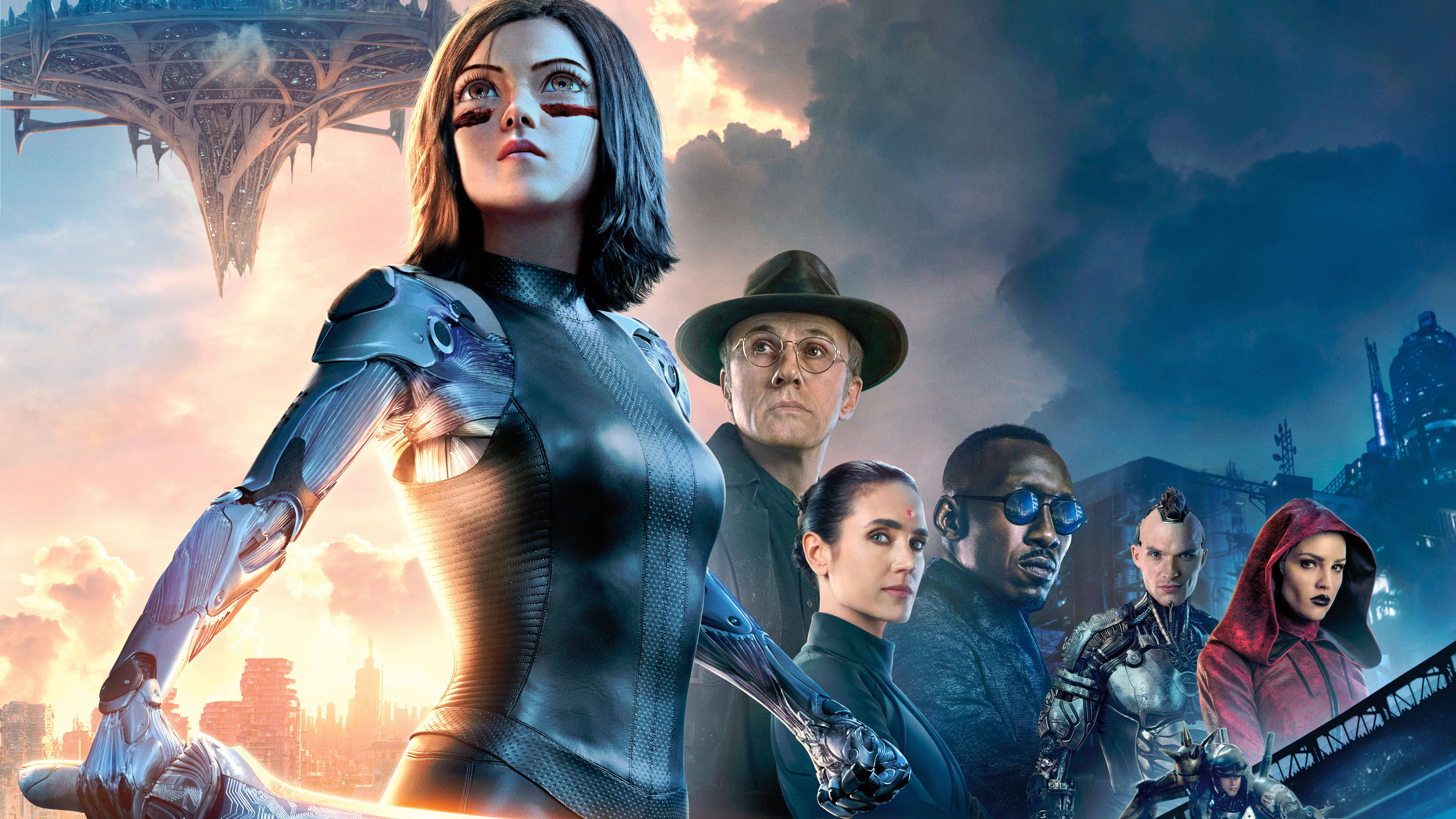 Alita Battle Angel 桌布 壁紙 — 一個由不同未來英雄組成的團隊，在戲劇性的日落天空下，背後有浮動建築和霓虹城市景觀，他們 defiantly 站立著。