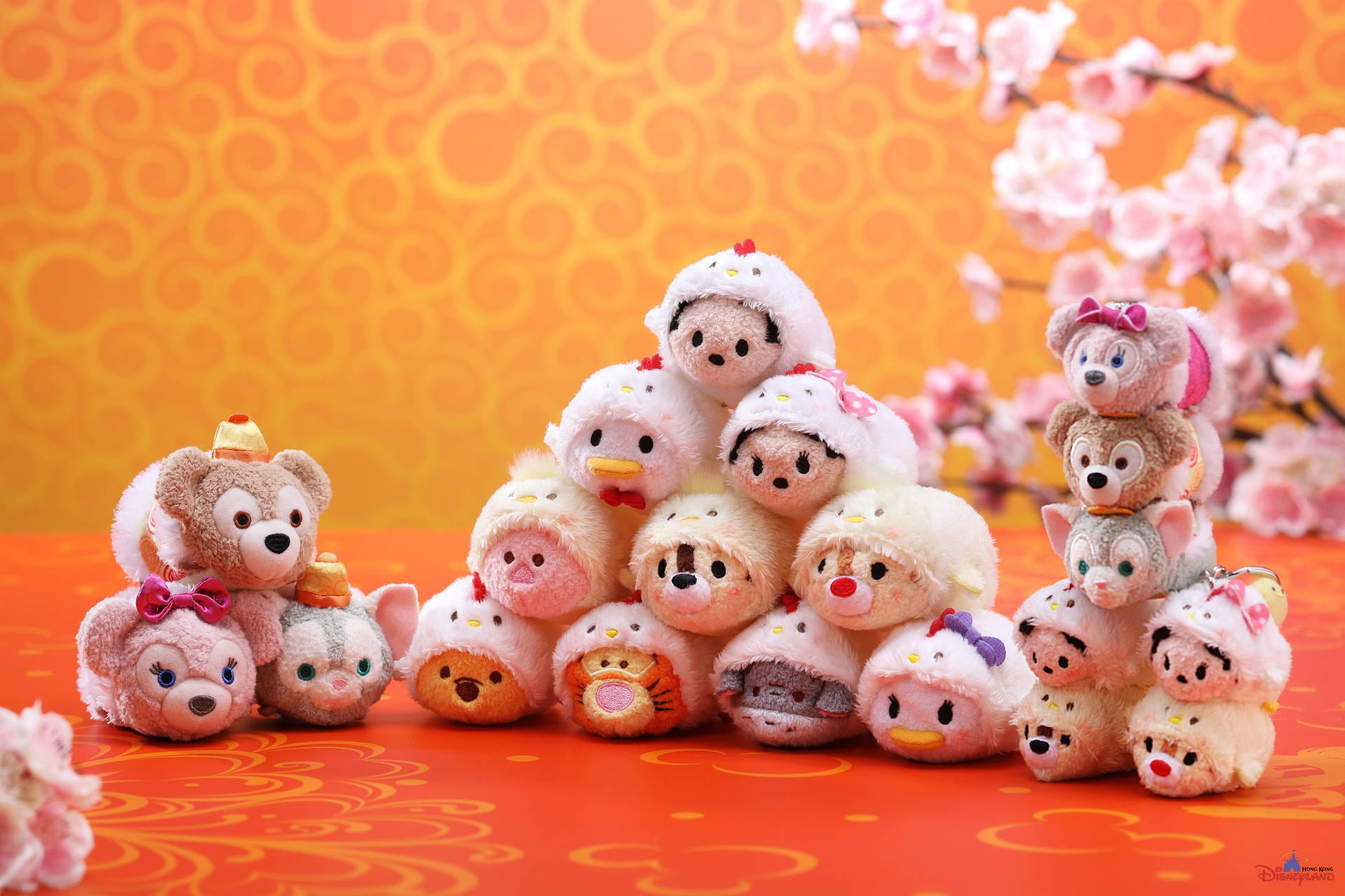 堆疊的Tsum Tsum絨毛玩具，背景是橙色和櫻花。 — Tsum tsum 壁紙