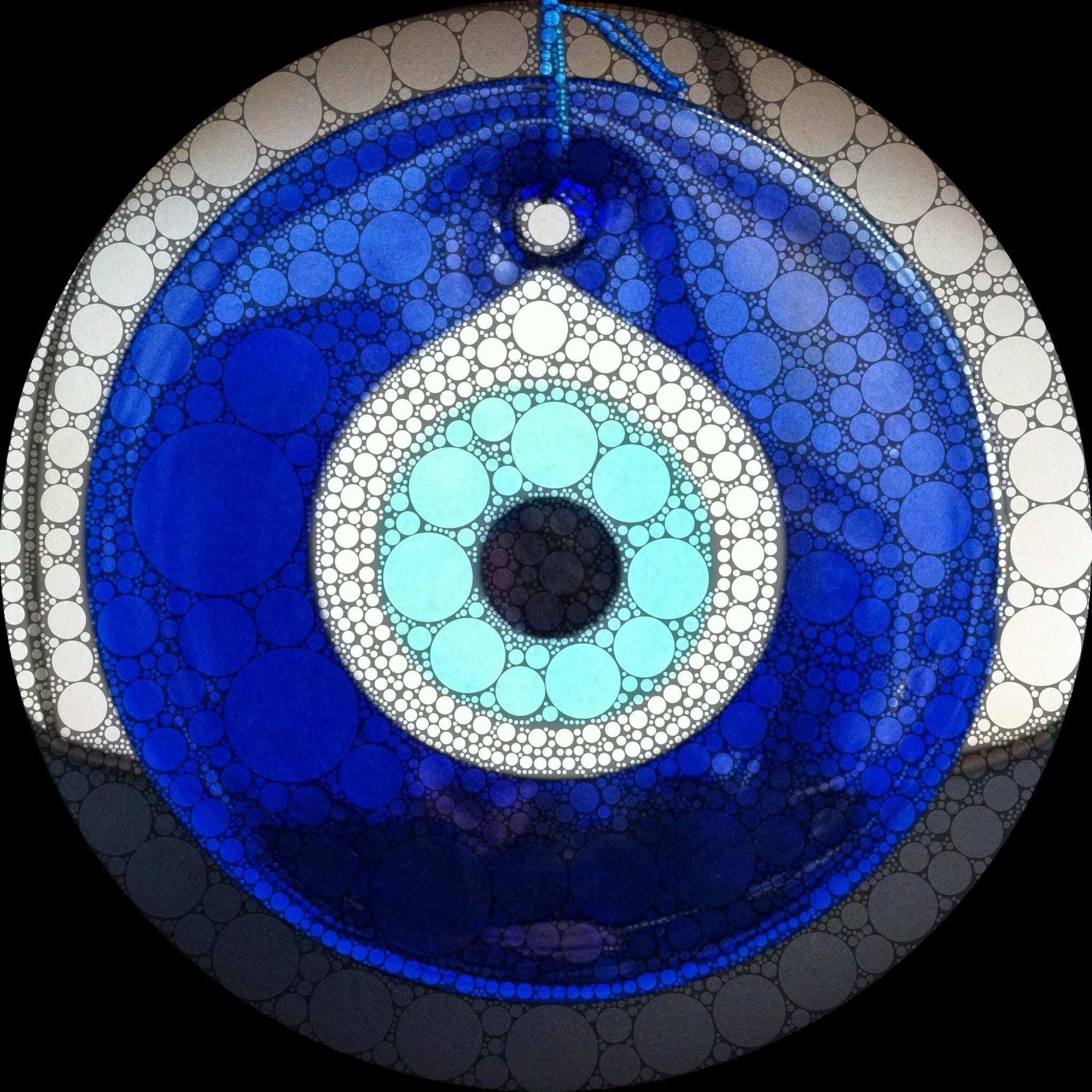 Evil Eye 桌布 壁紙 — 一個由層疊氣泡製成的圓形藍色邪惡之眼護身符懸掛在黑色背景上。