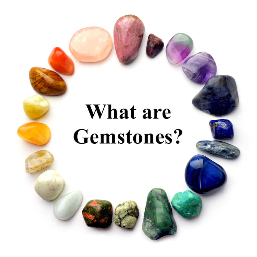 Gem Stone 桌布 壁紙 — 一個由拋光寶石組成的鮮豔彩虹圓圈，圍繞著「什麼是寶石？」的文字，背景為潔淨的白色。