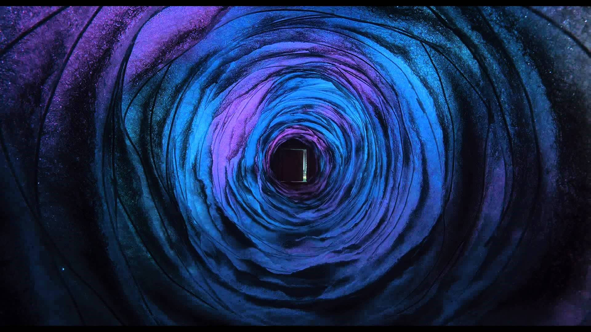 卡洛琳 桌布 壁紙 — 一個由深藍色和紫色組成的旋轉宇宙隧道，向內螺旋朝向一個發光的矩形傳送門。