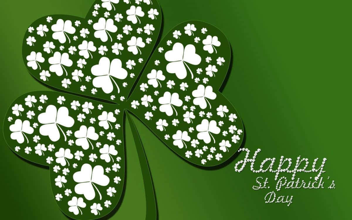Saint Patricks Day 桌布 壁紙 — 一個由白色三葉草組成的大型綠色四葉草，位於純綠色背景上，並帶有 'Happy St. Patrick's Day' 文字。