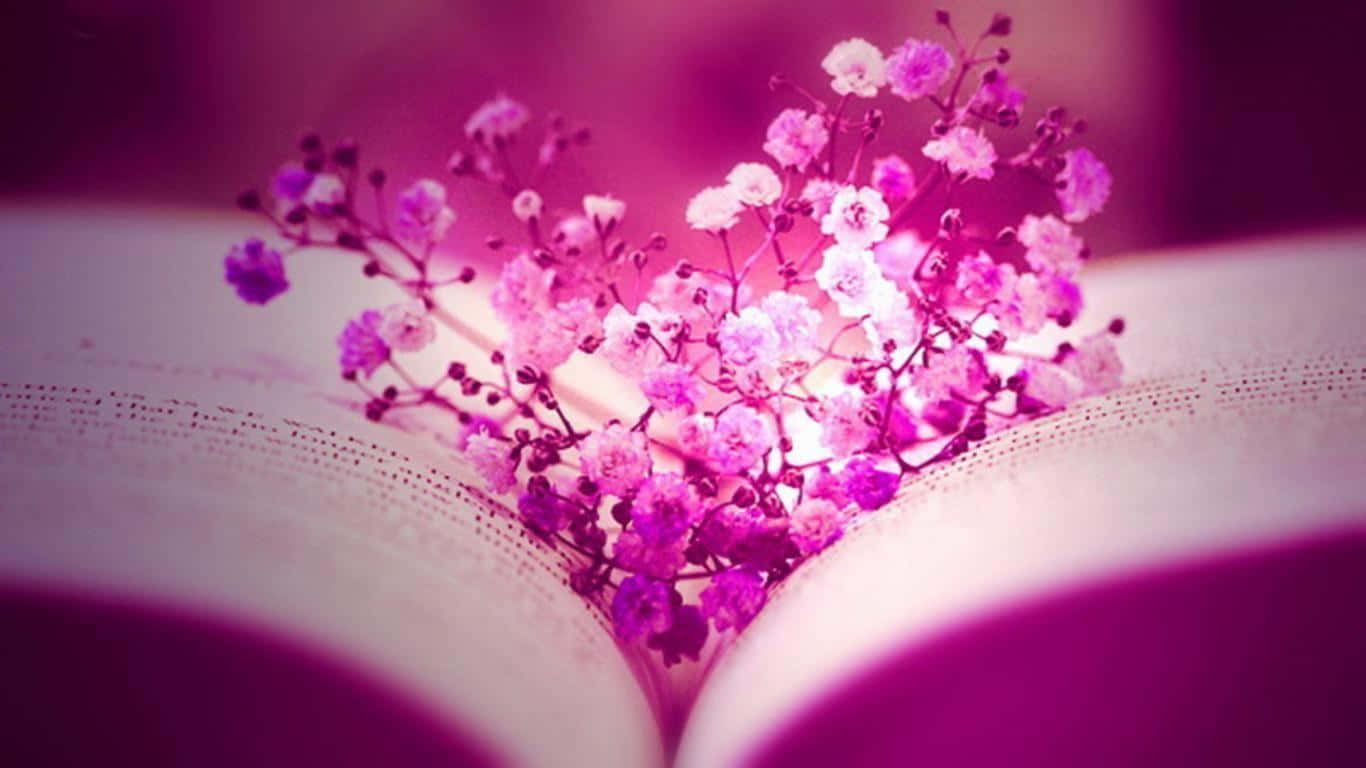 Facebook Cover 桌布 壁紙 — 一個由粉紅色和白色滿天星花朵組成的愛心形狀花藝，輕輕地放在一本沐浴在柔和紫色光線中的打開書頁上。