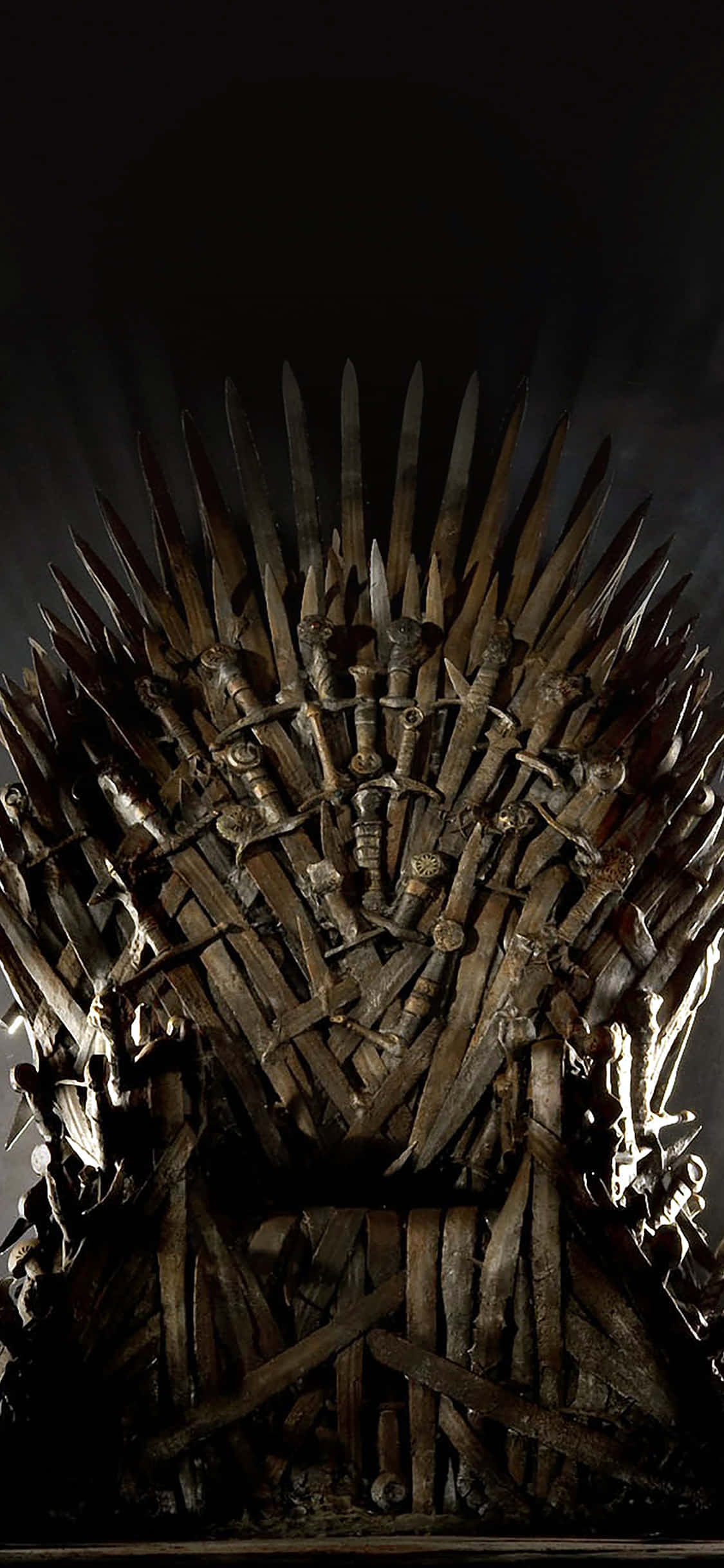 Game Of Thrones iPhone 桌布 壁紙 — 一個由鋸齒劍鑄成的威嚇王座，在黑暗虛空背景下於戲劇性聚光燈下發光。