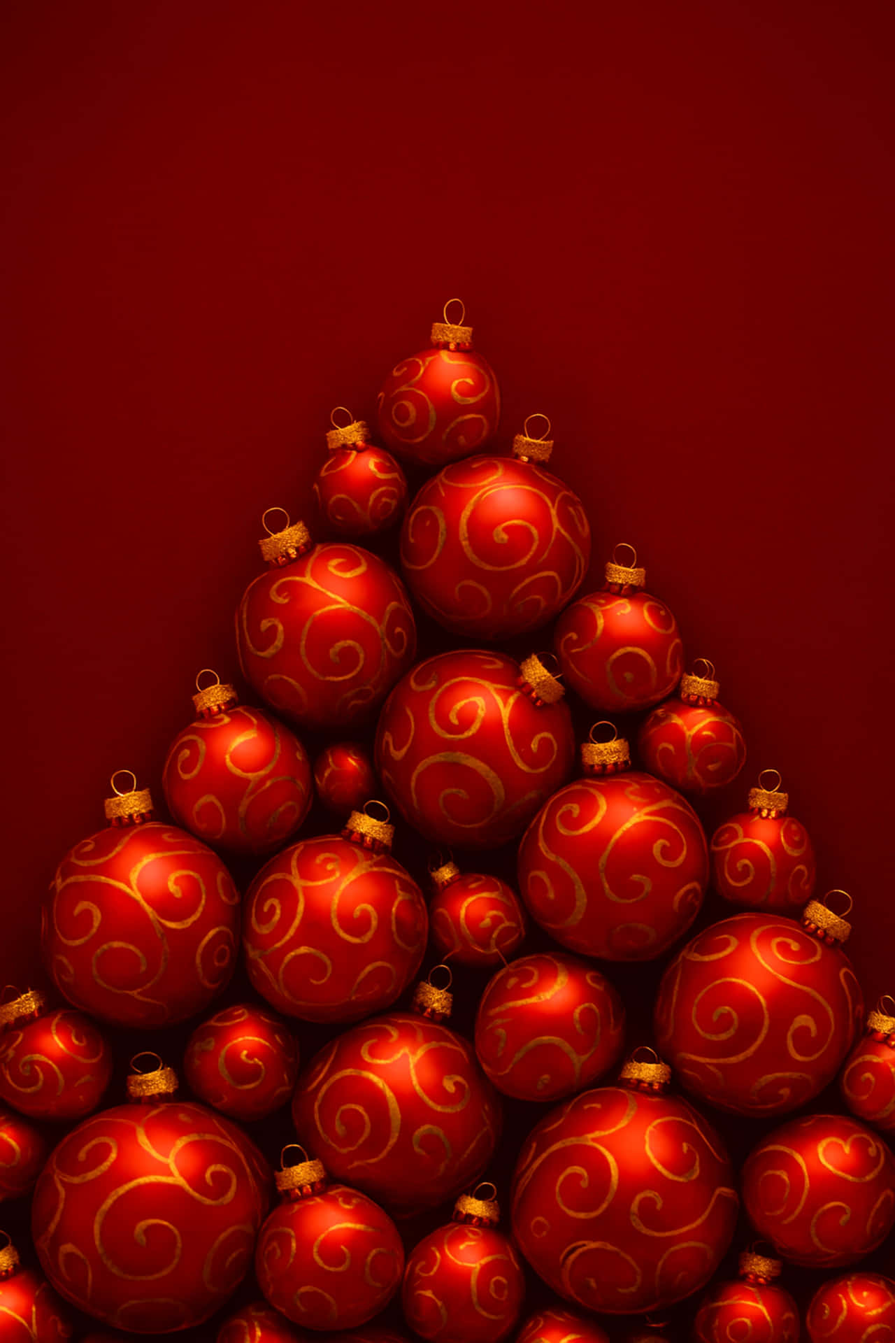 Red Christmas baubles pyramid shape 壁紙 — 一個由閃亮紅色聖誕裝飾品組成的金字塔，帶有金色漩渦圖案，矗立在深紅色背景上。