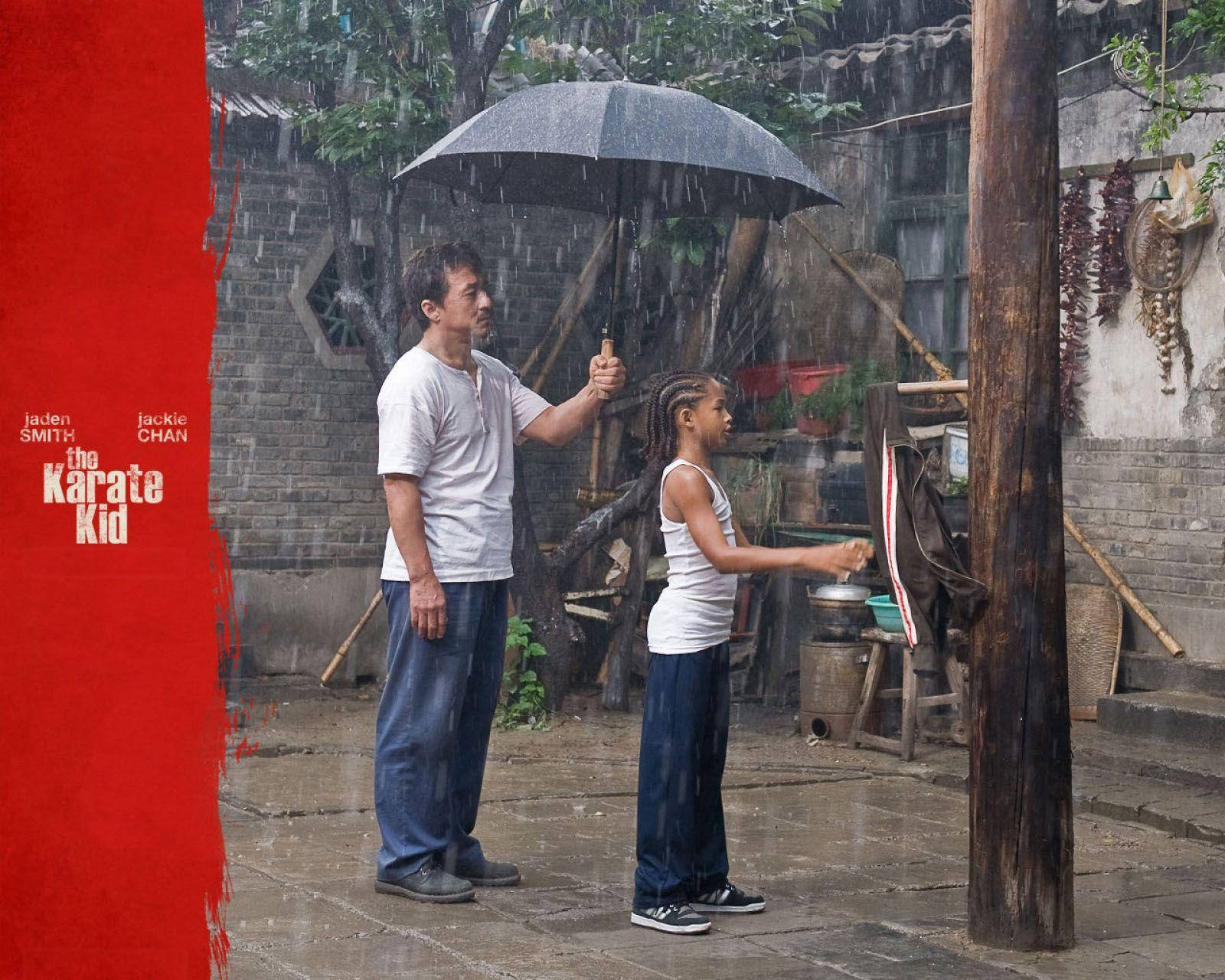 Raining 桌布 壁紙 — 一個男人和一個小女孩站在雨中的庭院裡，撐著一把傘，雨水在他們周圍流淌。