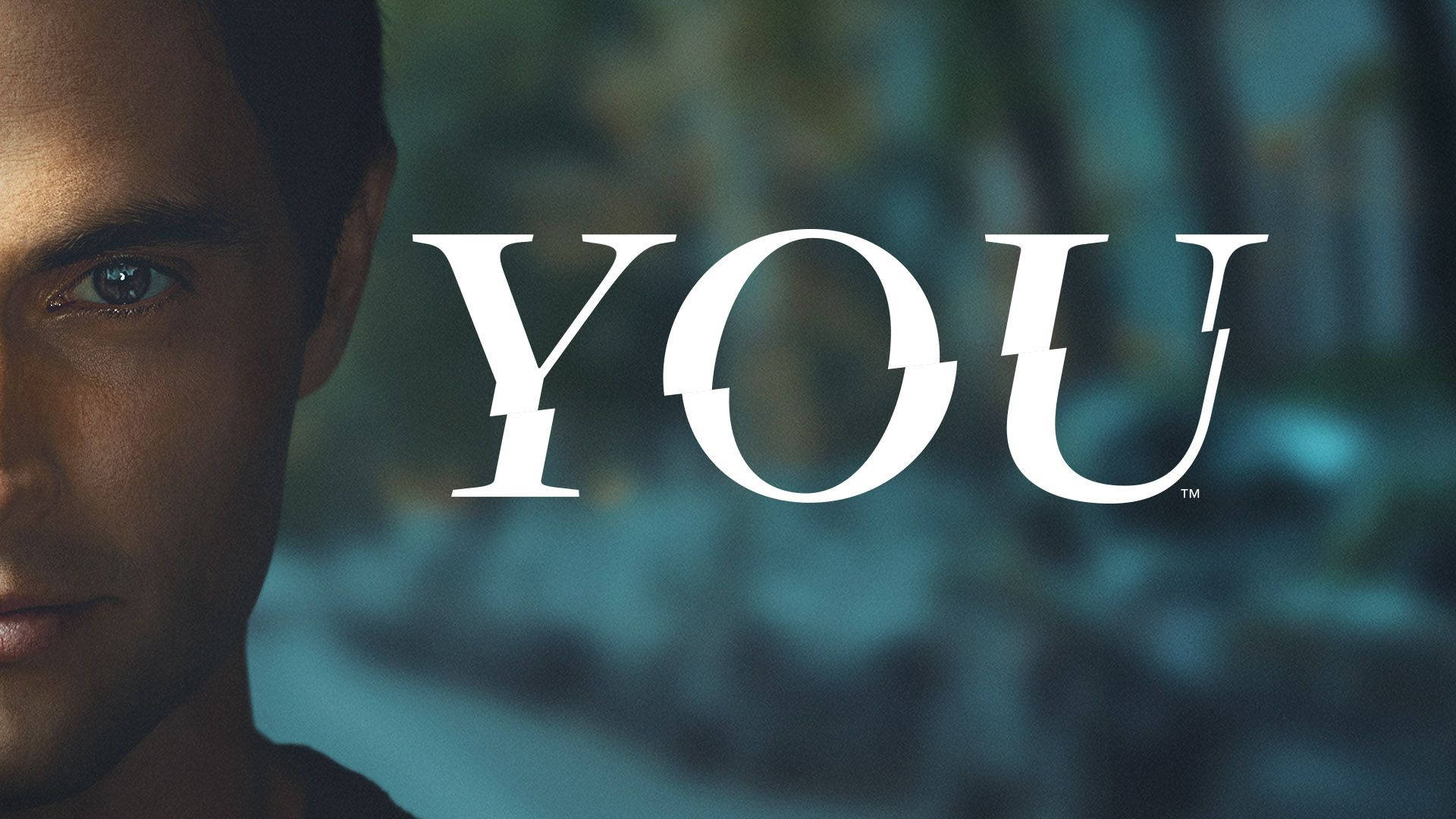 tv 桌布 壁紙 — 一個男人強烈目光的特寫，旁邊是粗體白色單詞「YOU」，背景是模糊的藍綠色。