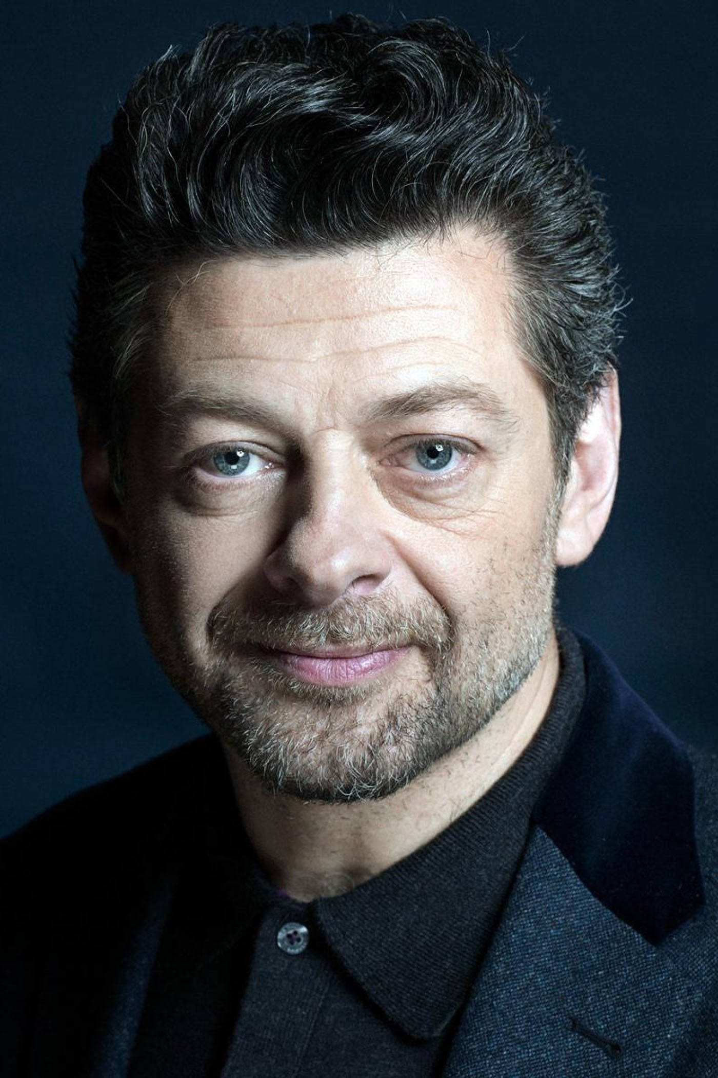 actor 桌布 壁紙 — 一個男人的特寫肖像，他有強烈的藍色眼睛和微妙的微笑，背景是深色。