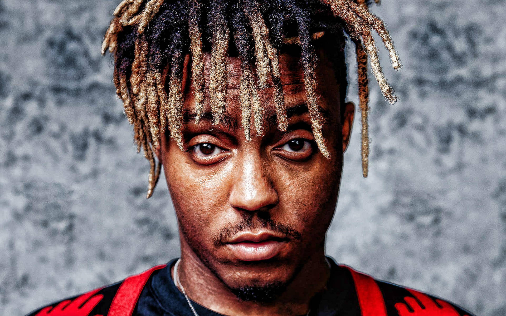 一個男人的肖像，他有辮子頭髮，穿著紅色和黑色的襯衫。 — Juice Wrld 壁紙