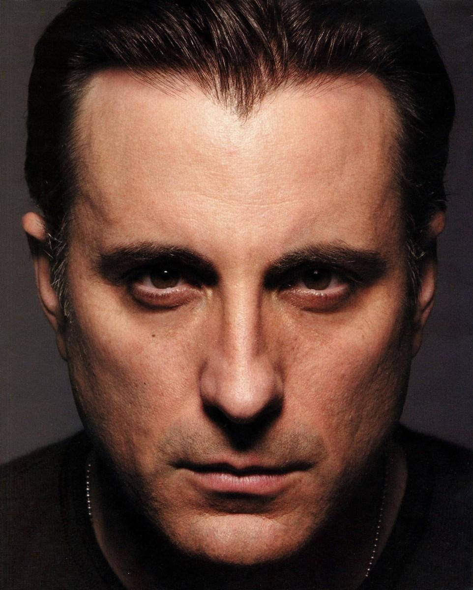 Andy Garcia 桌布 壁紙 — 一個男人的特寫肖像，他有銳利的眼睛和深色頭髮，背景是柔和的灰色。