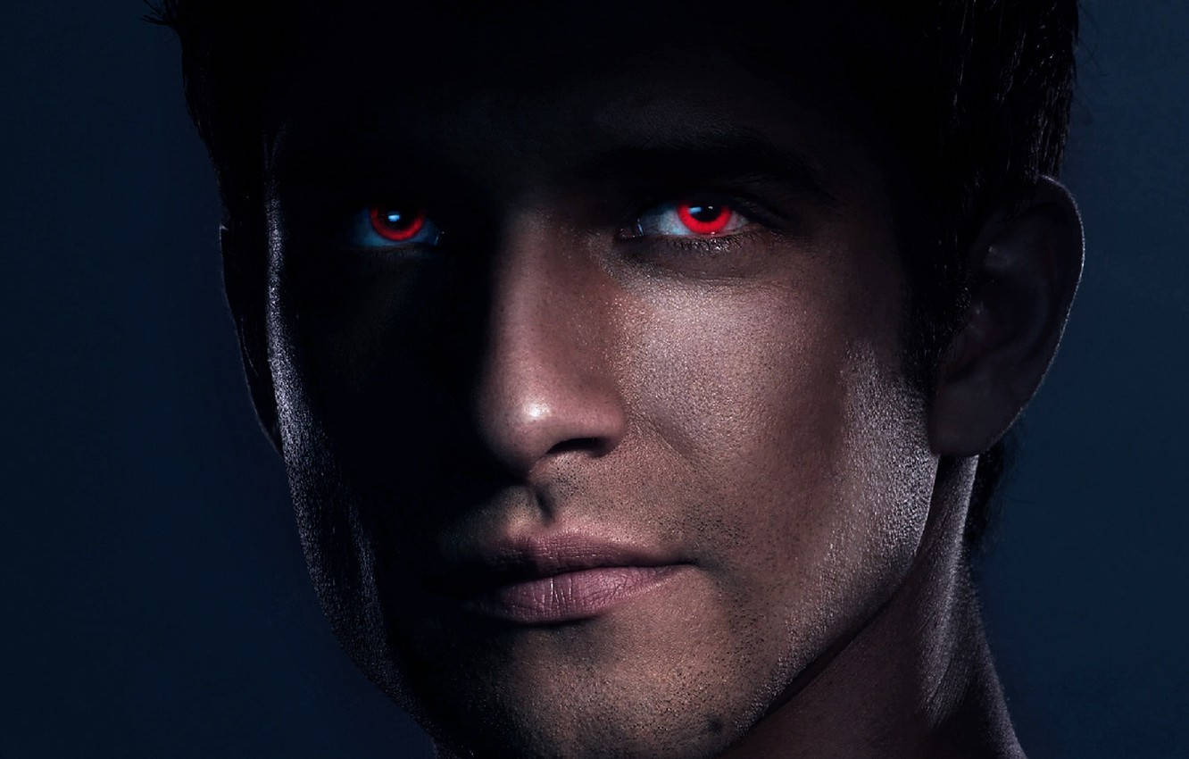 scott mccall 桌布 壁紙 — 一個男人的臉在陰影中，發光的紅色眼睛在深藍色背景下強烈凝視。