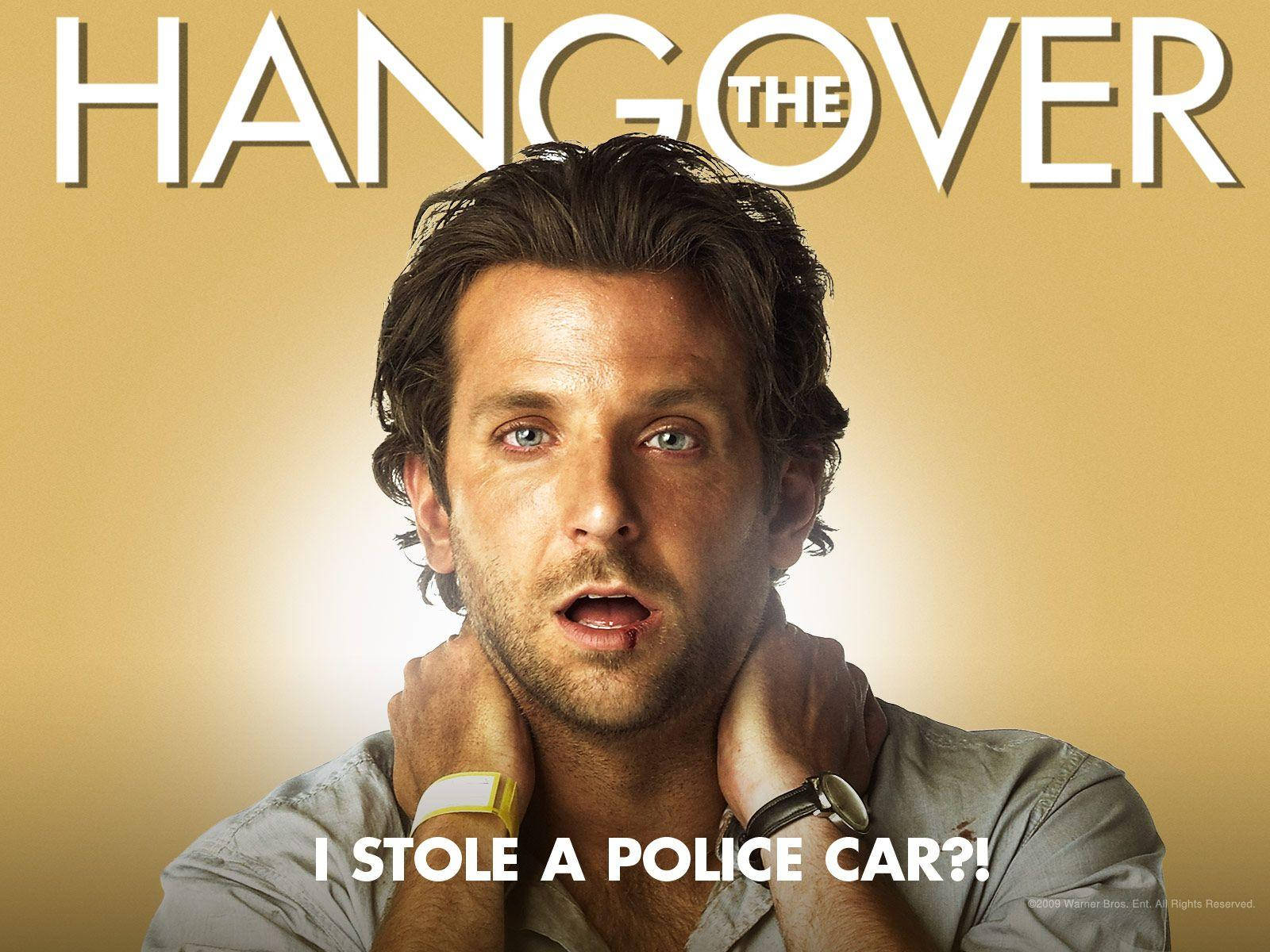 the hangover 桌布 壁紙 — 一個男人睜大眼睛，雙手放在脖子上，震驚地盯著金色背景上的粗體文字「THE HANGOVER」和「I STOLE A POLICE CAR?!」