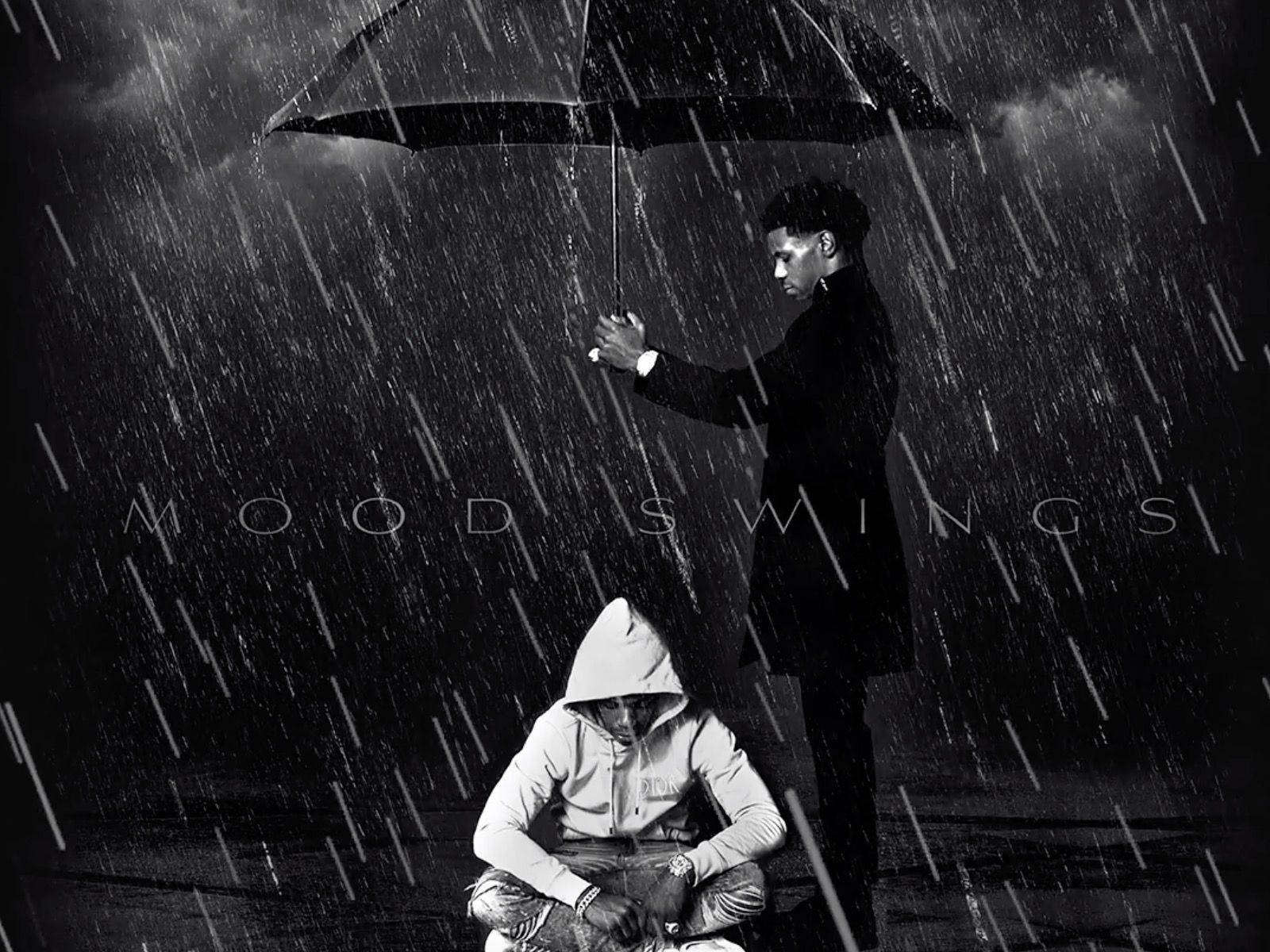 Raining 桌布 壁紙 — 一個男人站著，在黑暗的天空下，在大雨中為一個坐著的孩子撐傘。