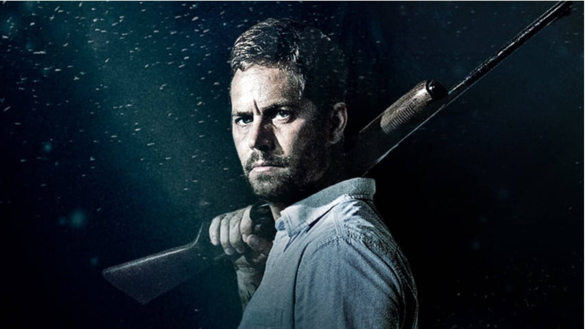 Paul Walker 桌布 壁紙 — 一個男人肩上扛著步槍，在黑暗、雨點飛濺的環境中，在戲劇性的燈光下凝視著。