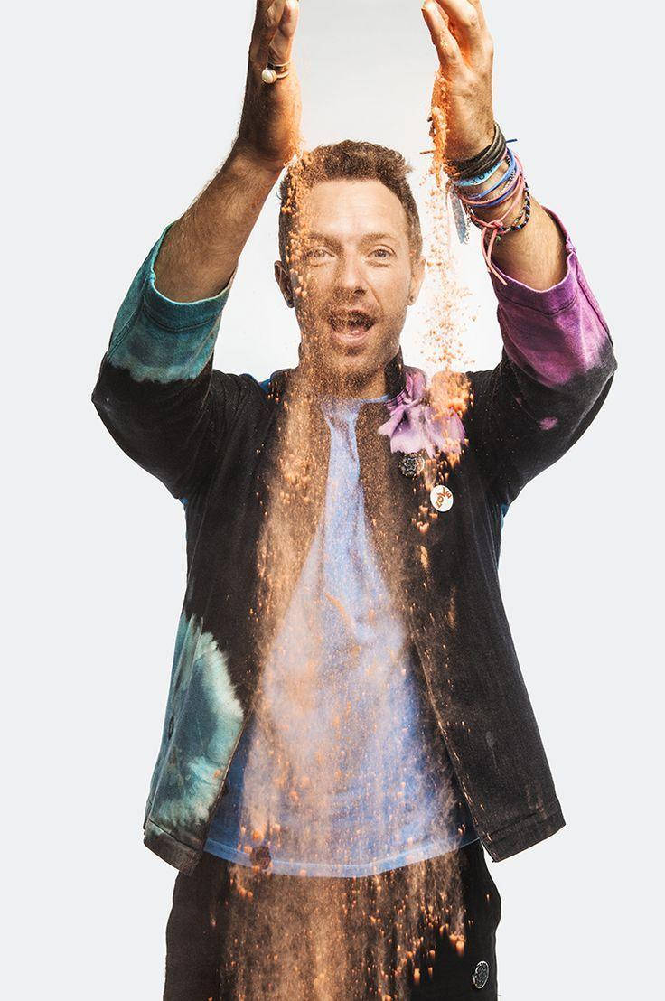 Chris Martin 桌布 壁紙 — 一個男人舉起雙臂，讓金色沙粒穿過他的手指，在純白色背景前流淌。