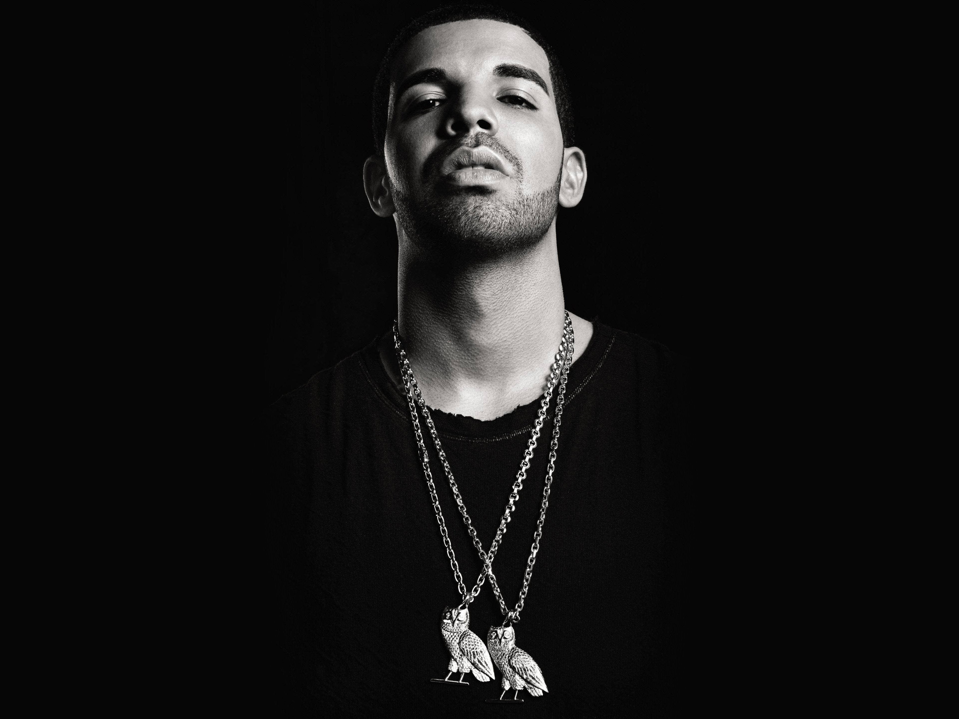 Drake 桌布 壁紙 — 一個男人閉著眼睛，戴著貓頭鷹吊墜項鍊，在黑暗背景下的黑白肖像。