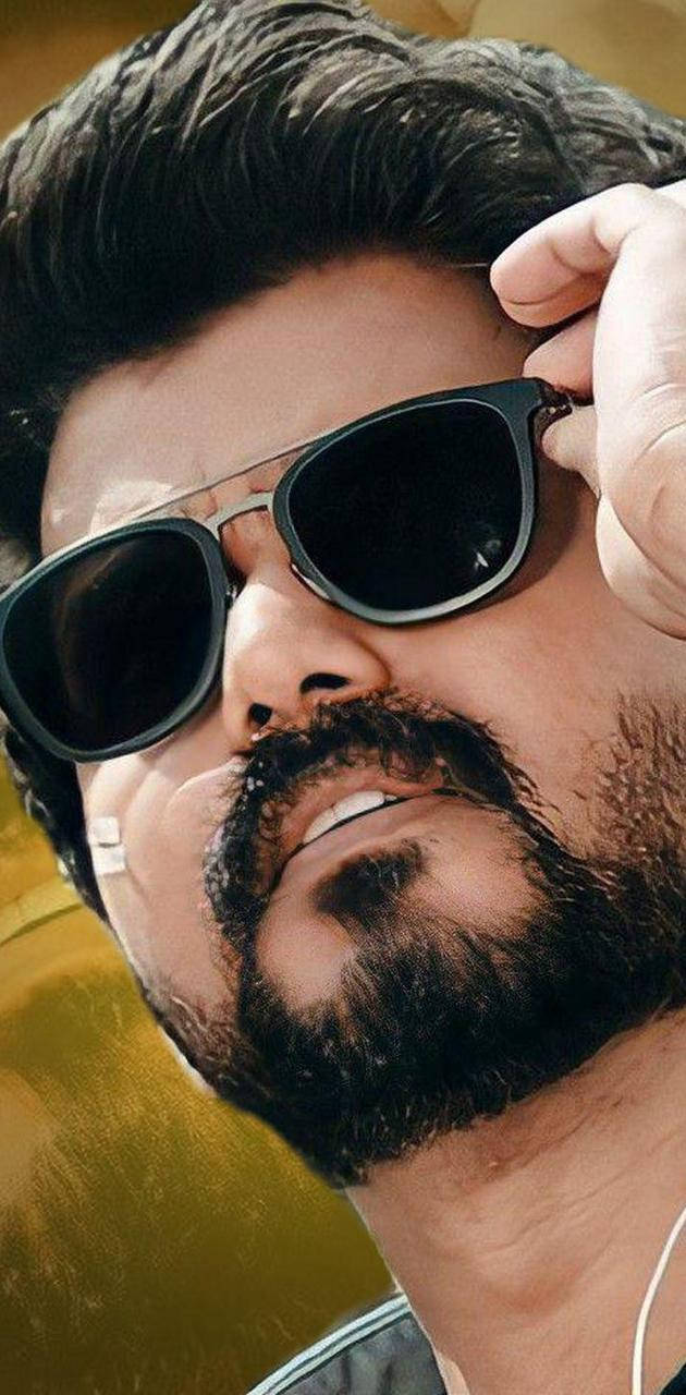 Sunglasses 桌布 壁紙 — 一個留著濃密鬍鬚、戴著太陽眼鏡的男人，在金色背景前自信地微笑著調整眼鏡。