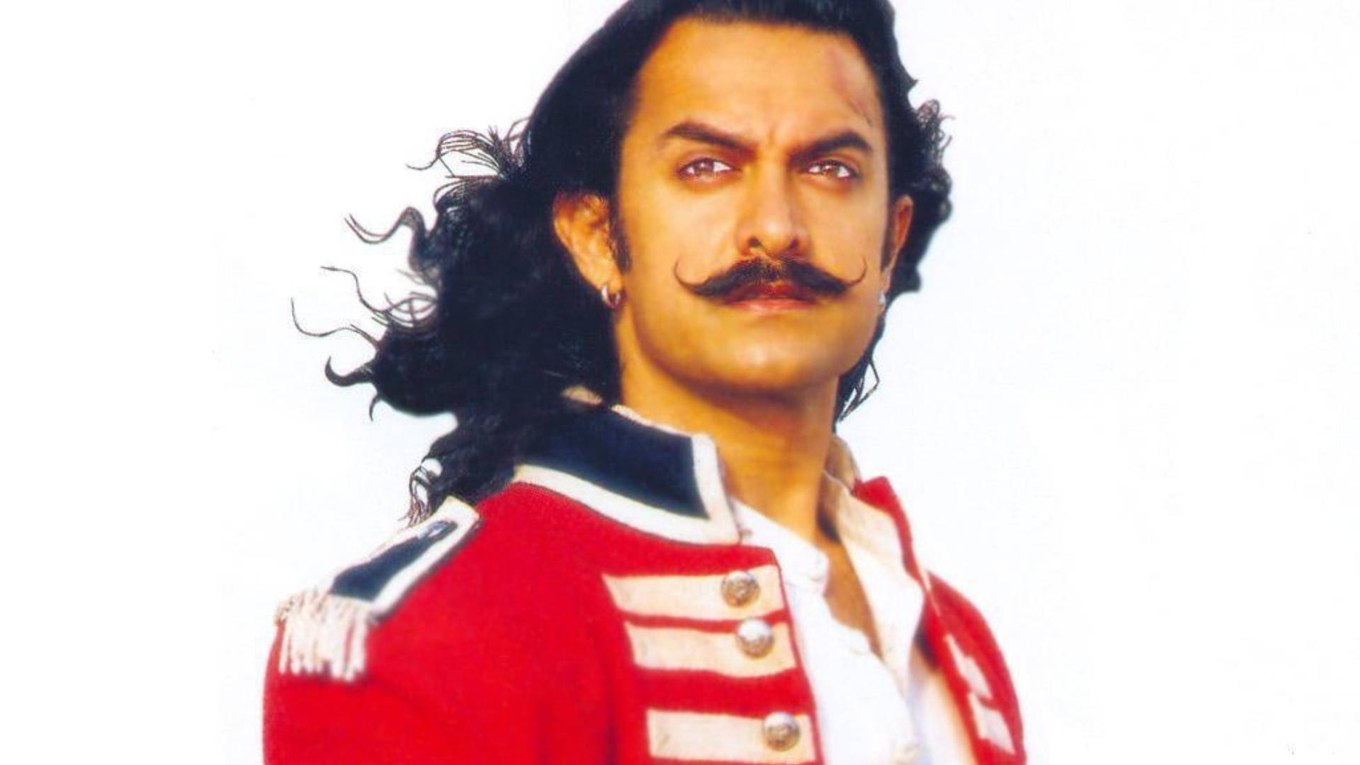 Aamir Khan 桌布 壁紙 — 一個留著濃密鬍鬚和長黑髮的男人，在白色背景前穿著紅色軍裝外套。