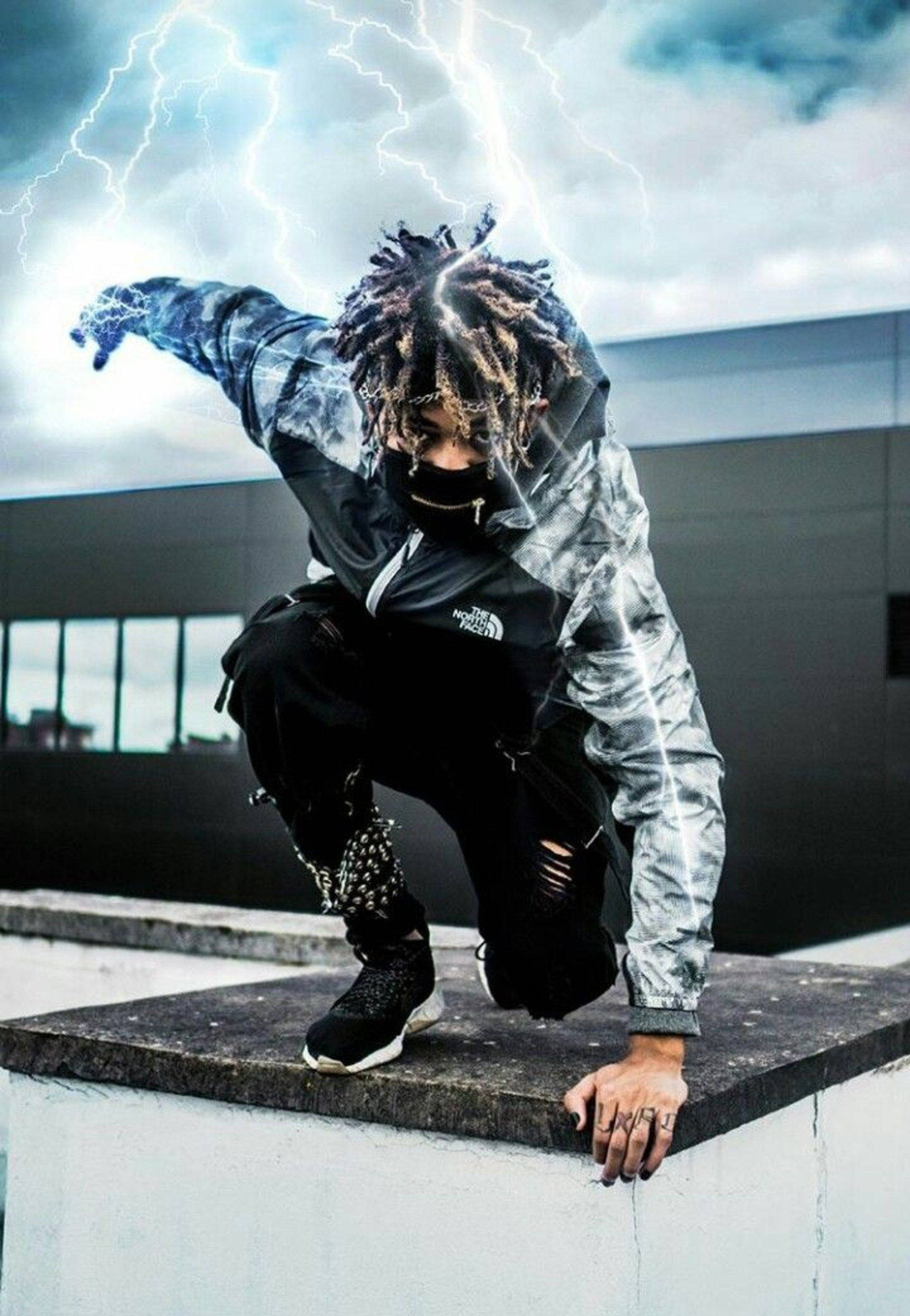 Scarlxrd 桌布 壁紙 — 一個留著辮子的人蹲在屋頂上，背後閃電劃破暴風雨的天空。