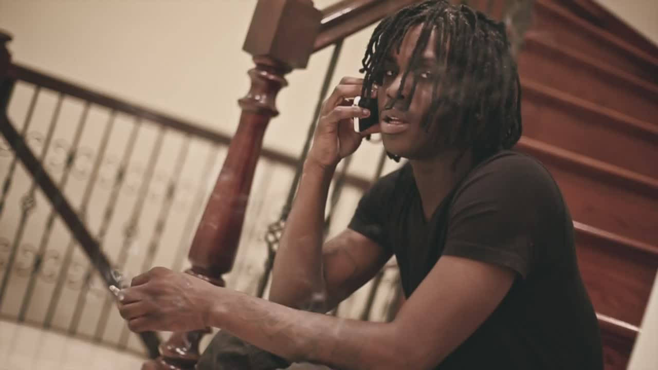 Chief Keef 桌布 壁紙 — 一個留著辮子的年輕男子坐在木樓梯上，一邊講電話一邊拿著香煙。