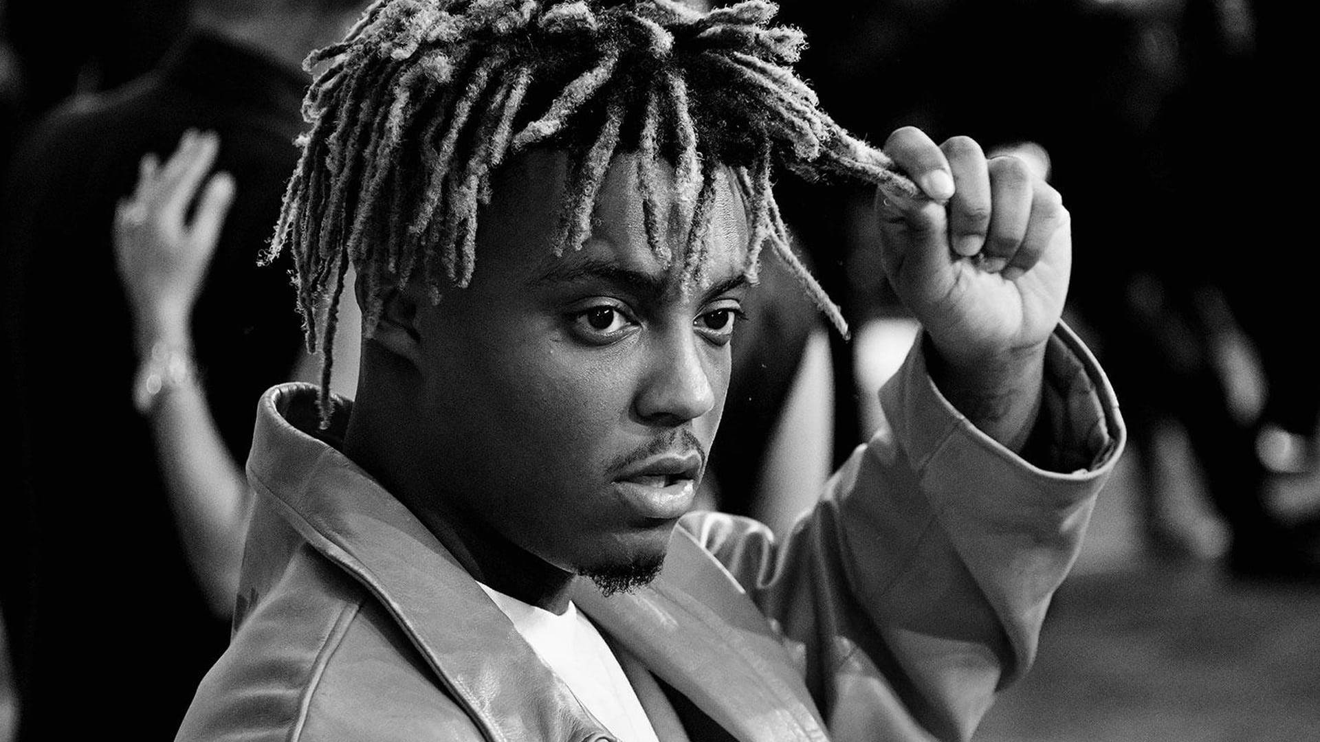 Juice Wrld Desktop 桌布 壁紙 — 一個留著辮子頭的男人在黑白肖像中一邊調整頭髮一邊專注地看著相機。