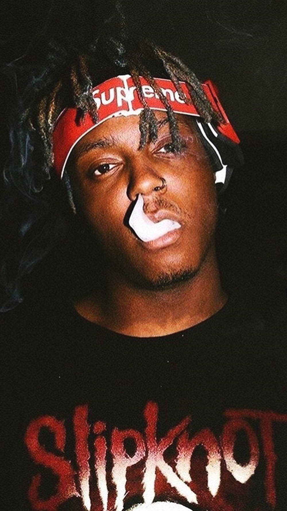 留著辮子頭的男人戴著Supreme頭帶和穿著Slipknot襯衫呼出煙霧。 — Juice Wrld 壁紙