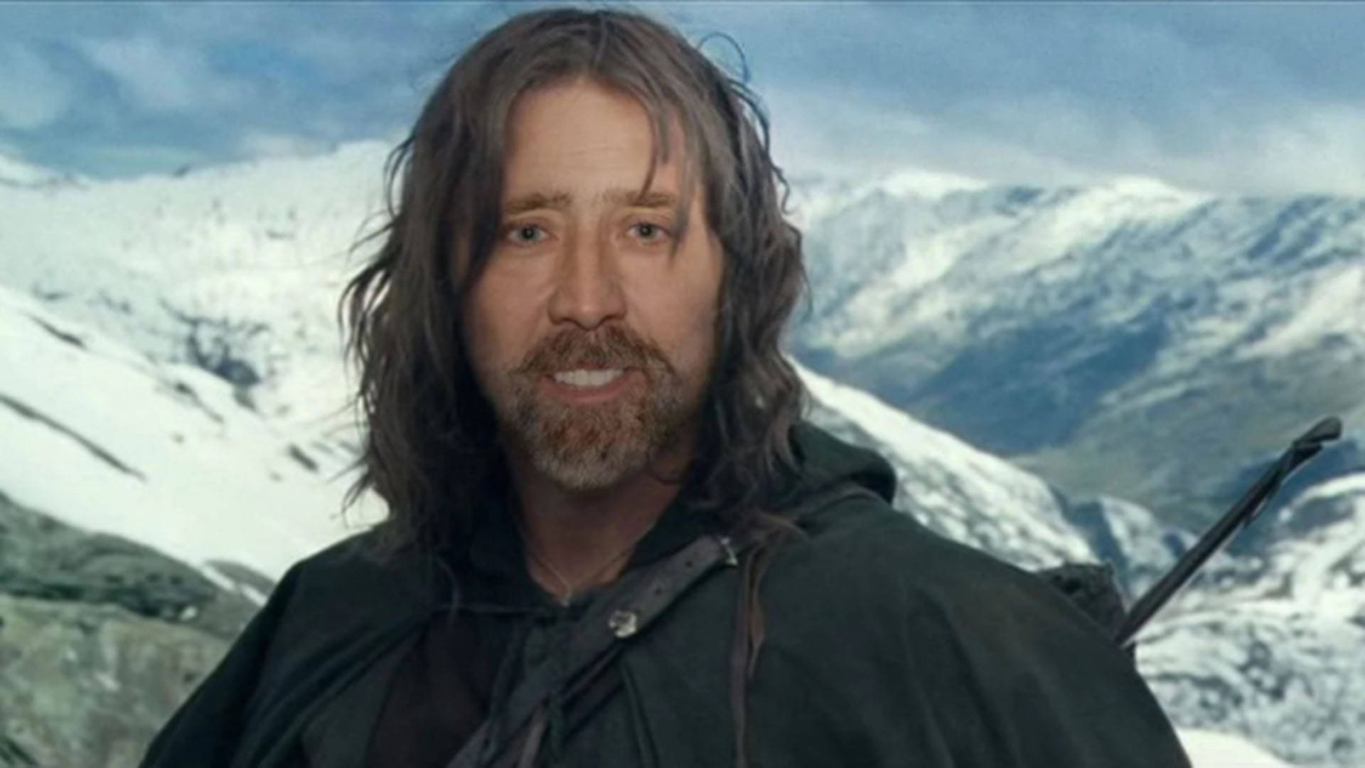 nicolas cage meme 桌布 壁紙 — 一個留著鬍子、長髮的男人站在陰天天空下、白雪覆蓋的山脈前。
