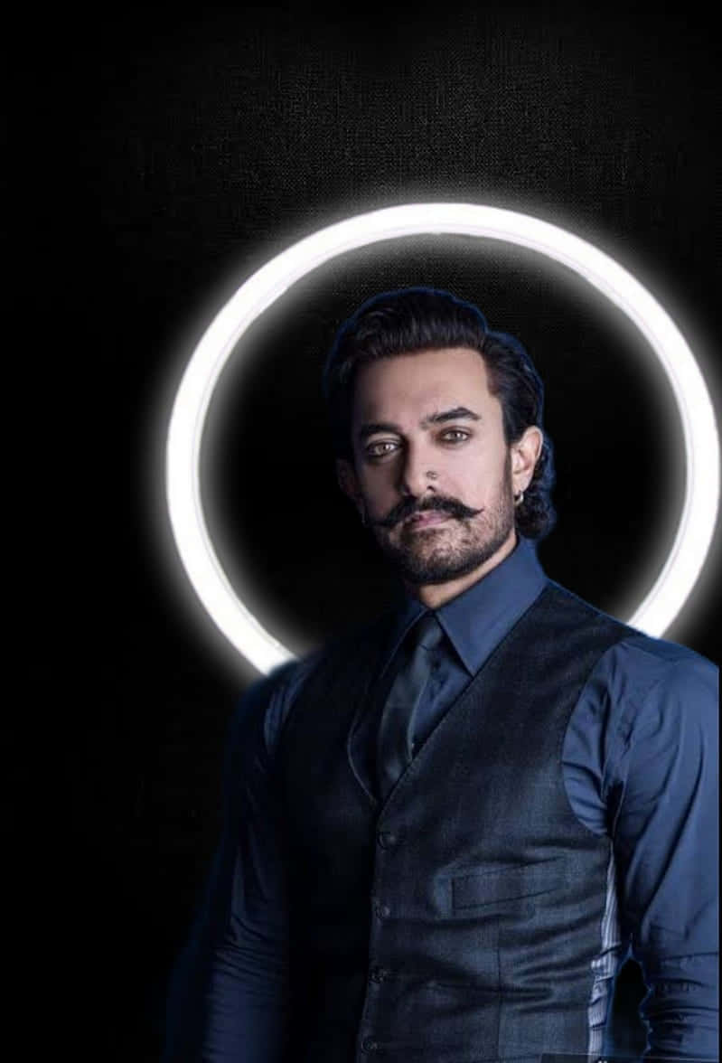Aamir Khan 桌布 壁紙 — 一個留著鬍鬚和鬍子的男人自信地站在黑色背景前一個發光的白色圓環前。
