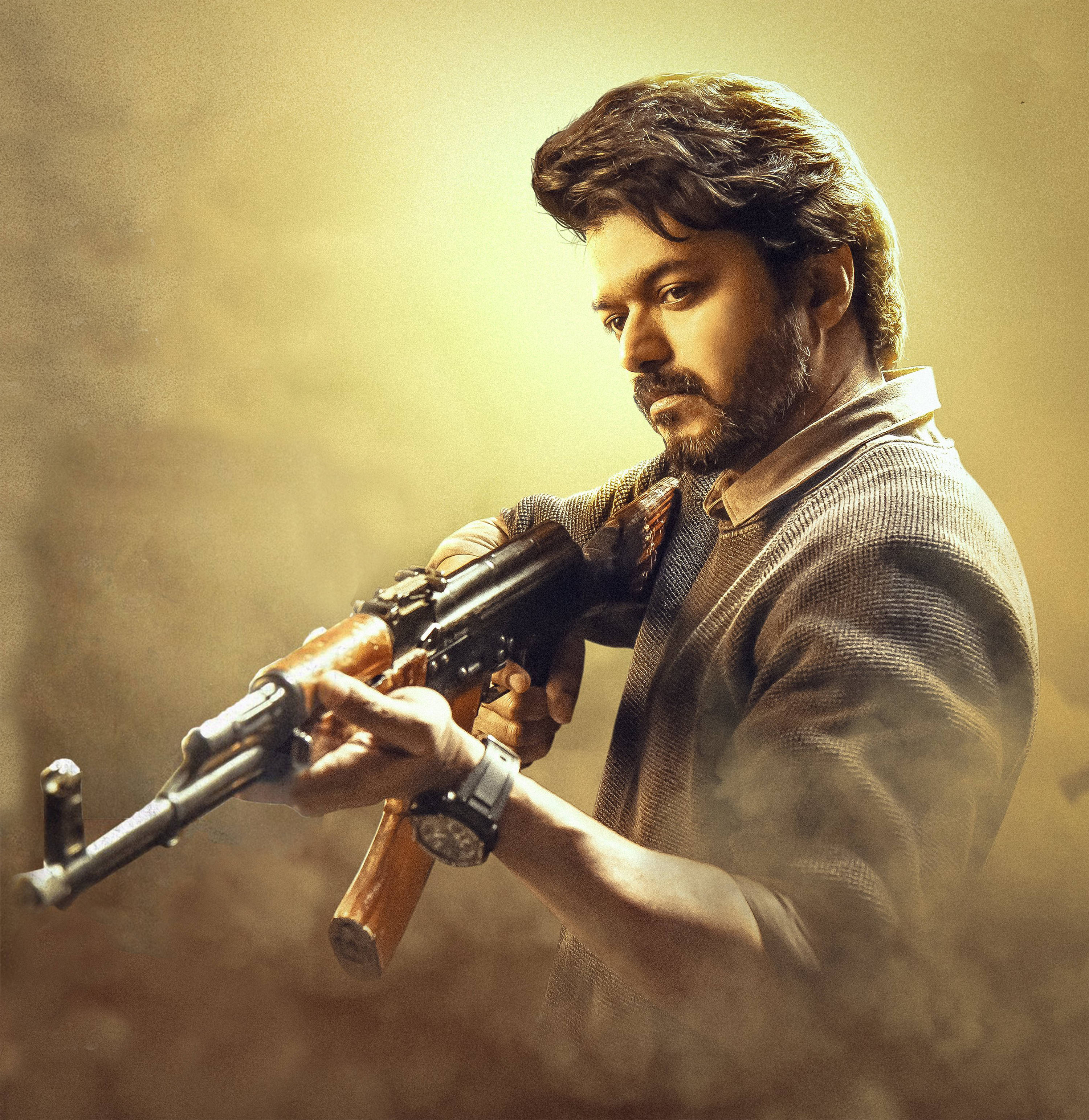 vijay HD 桌布 壁紙 — 一個留鬍子的男人在煙霧瀰漫、金色燈光的場景中，專注地握著一支AK-47步槍。
