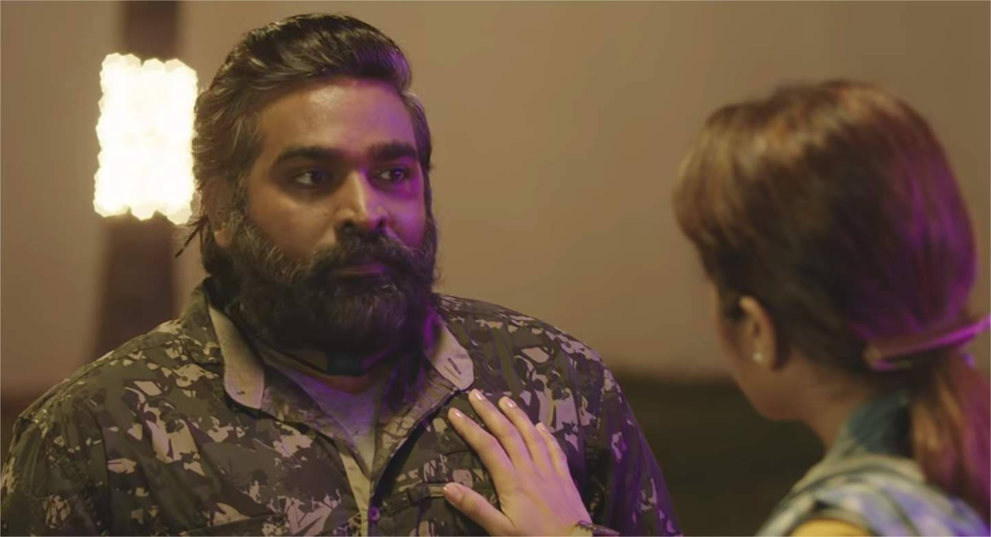 vijay HD 桌布 壁紙 — 一個留鬍鬚、身穿圖案襯衫的男人，在溫暖的紫色燈光下，專注地看著一個將手放在他胸膛上的女人。