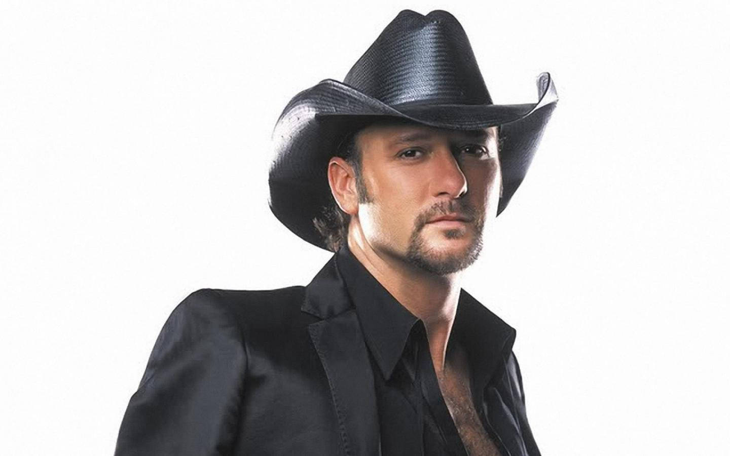 Tim Mcgraw 桌布 壁紙 — 一個留鬍鬚的男人，戴著黑色牛仔帽，穿著黑色襯衫，背景是純白色。