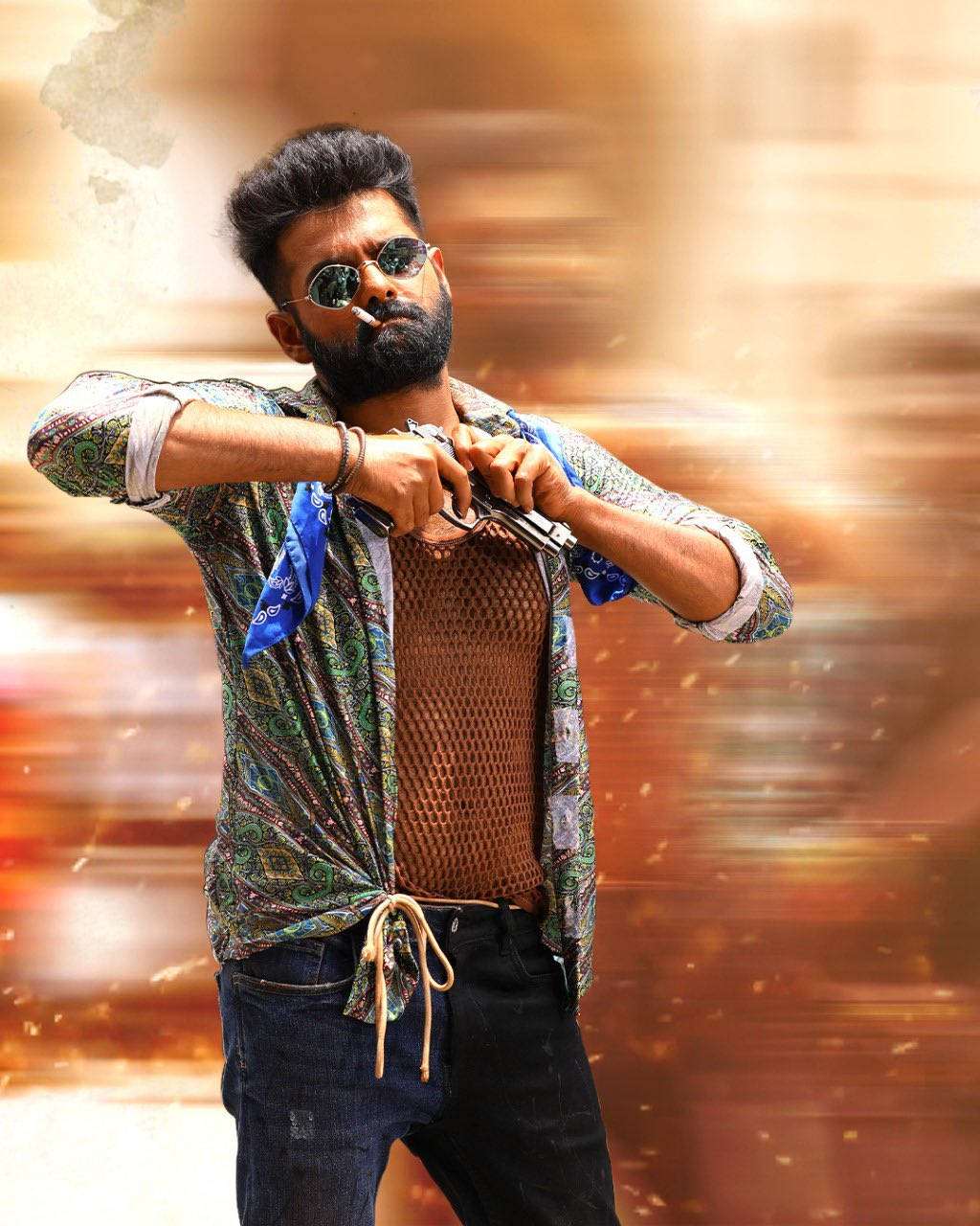 Ram Pothineni 桌布 壁紙 — 一個留鬍鬚的男人戴著太陽眼鏡和花紋襯衫，在模糊的火焰背景前專注地握著一把手槍。
