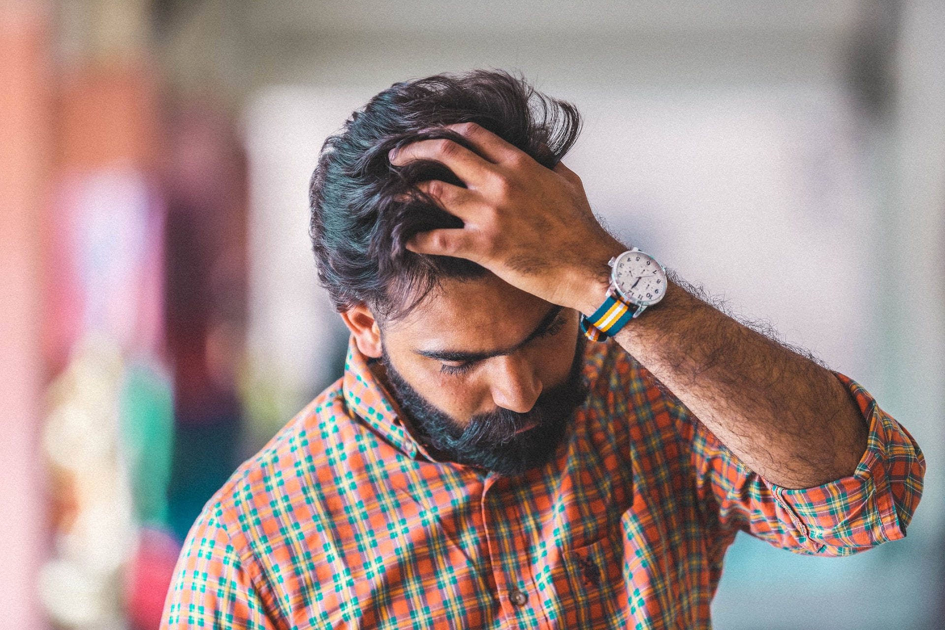 Haircut 桌布 壁紙 — 一個留鬍鬚的男人穿著格紋襯衫，帶著沮喪的表情用手撥頭髮。