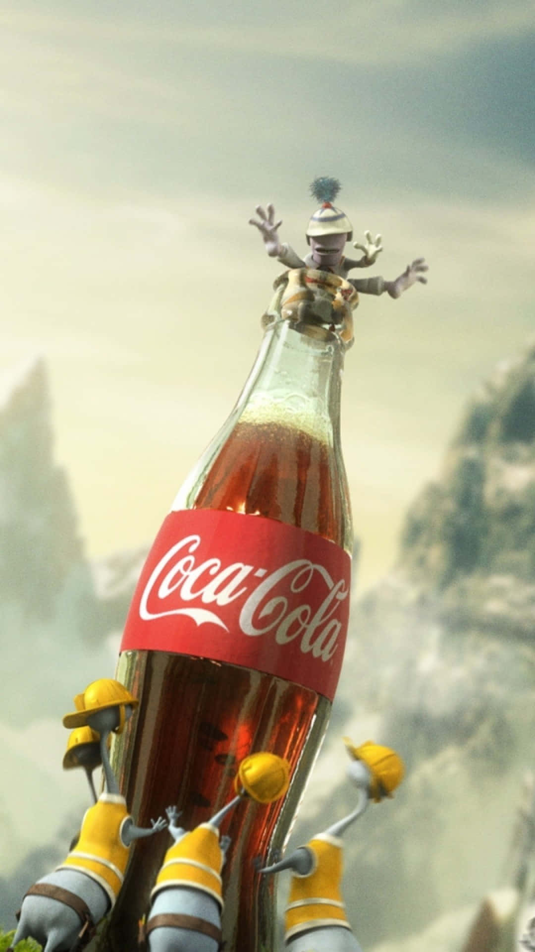coca cola 桌布 壁紙 — 一個異想天開的動畫場景顯示，一個微型工人坐在一個巨大的可口可樂瓶上，由微型建築機器人穿過霧氣瀰漫的山區景觀運送。
