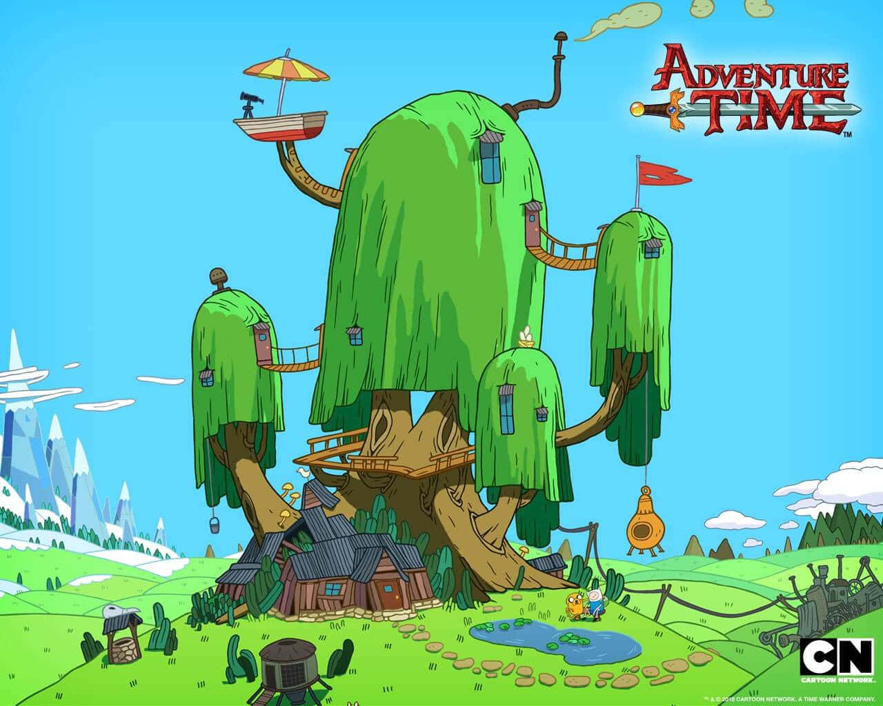 Adventure Time Cute 桌布 壁紙 — 一個異想天開的卡通樹屋村莊，擁有綠色樹冠和木製步道，背景是明亮的藍天和遠處的雪山。