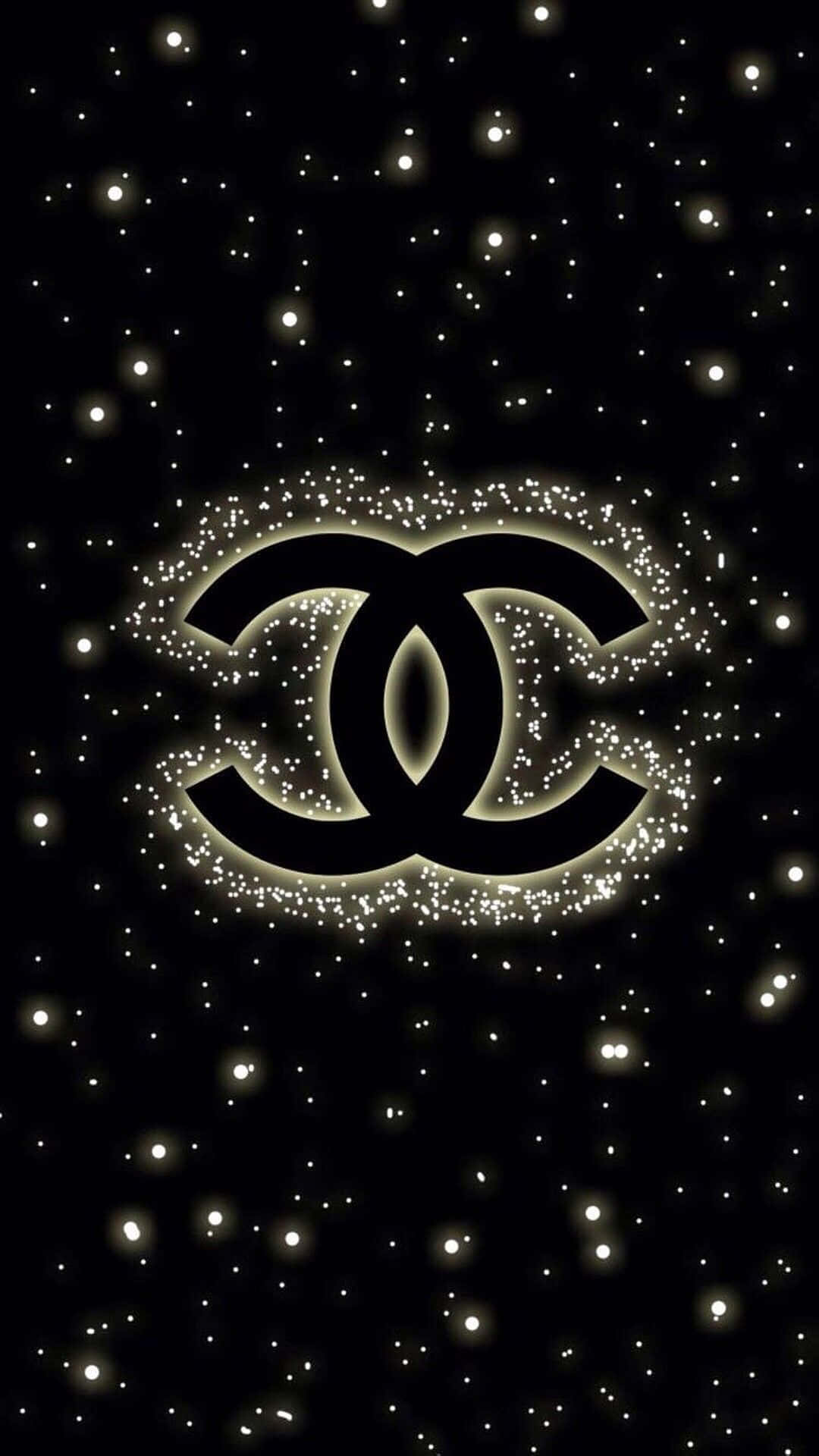 香奈兒標誌 桌布 壁紙 — 一個發光的 Chanel 標誌，被閃爍的星星環繞，背景為黑色。