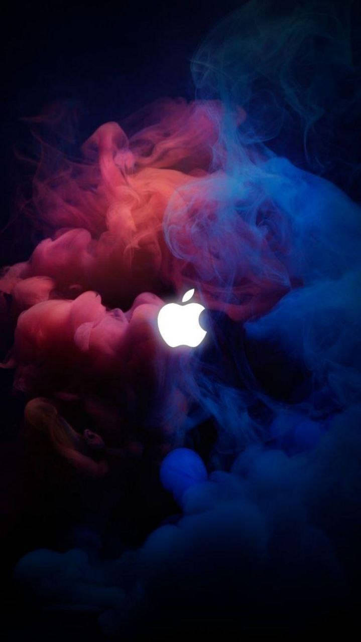 iPhone 桌布 壁紙 — 一個發光的Apple標誌從旋轉的紅色和藍色煙霧中浮現，背景為深色。