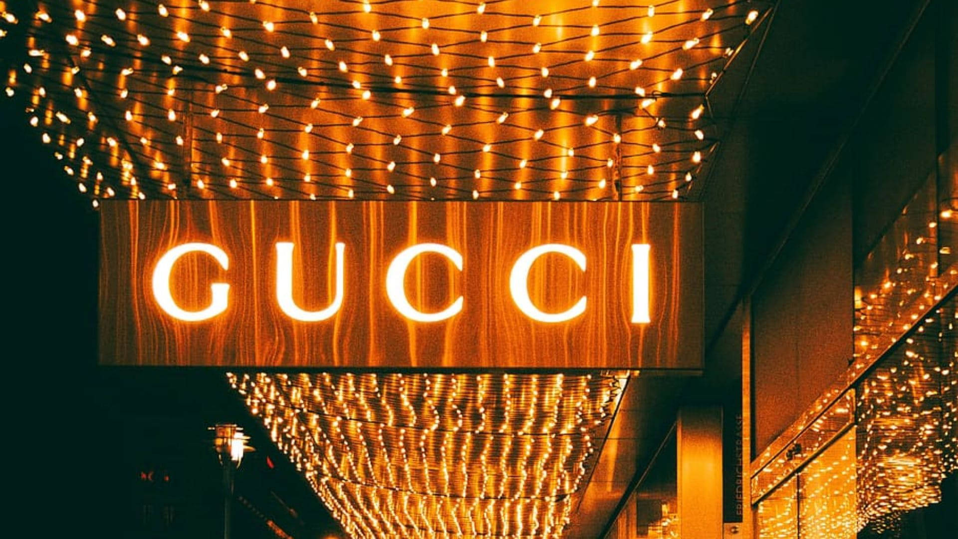夜晚在串燈下發光的Gucci商店標誌。 — Gucci GIF 壁紙