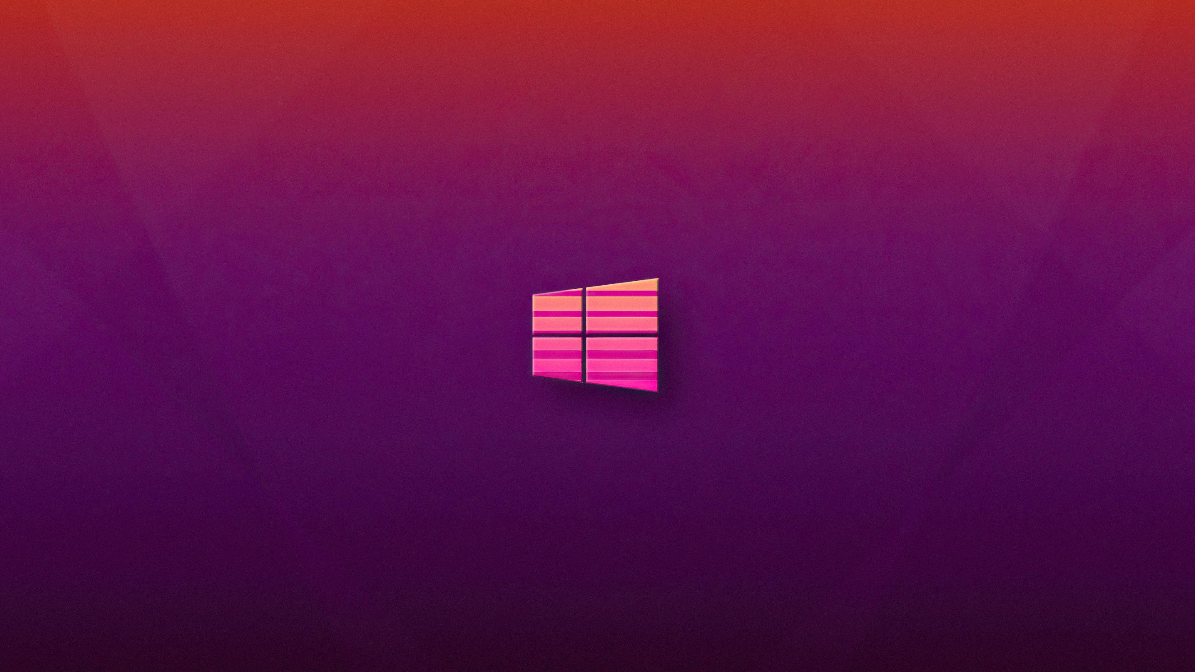 Windows 11 桌布 壁紙 — 一個發光的Windows標誌，居中於漸變紫色和紅色背景上，帶有柔和的光線。