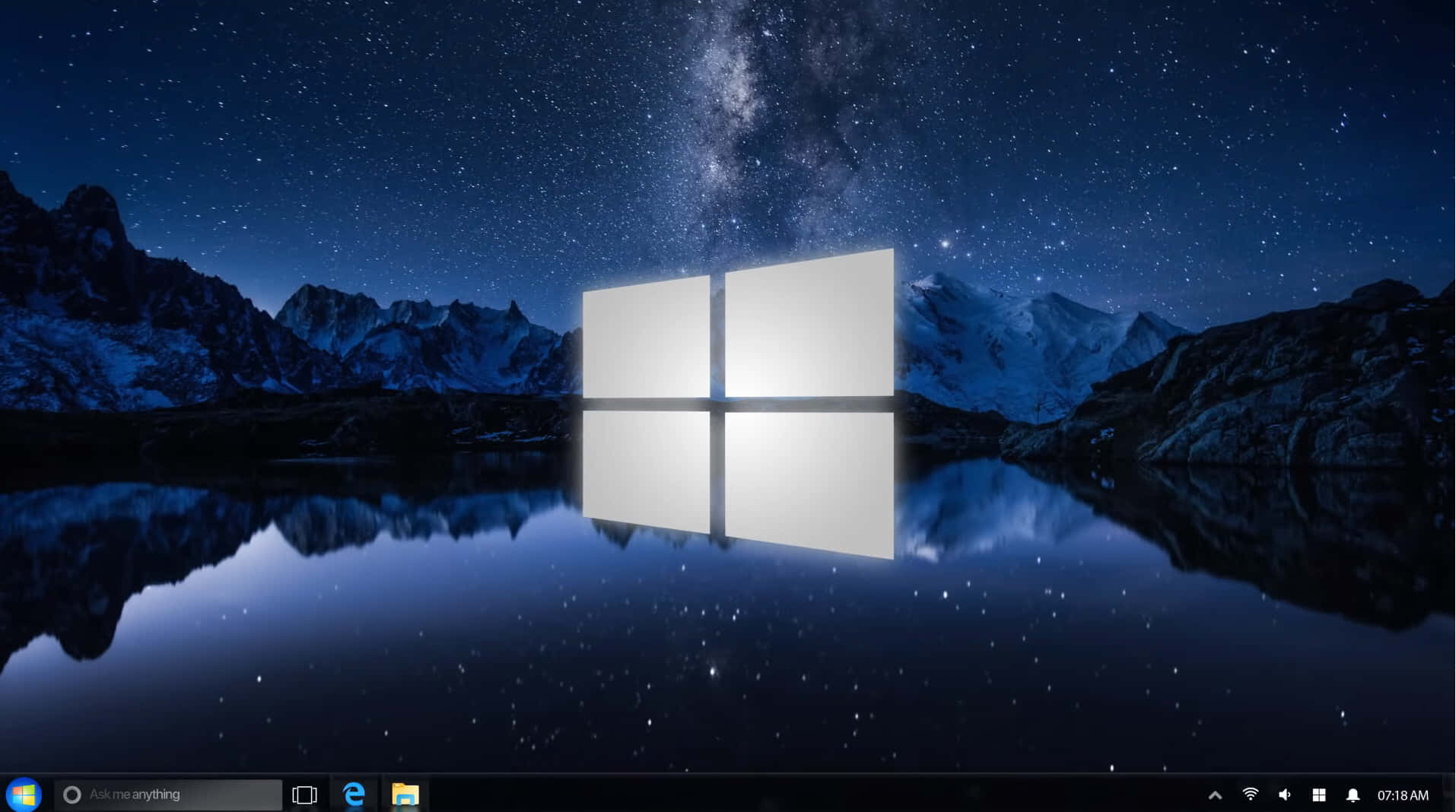 Windows 7 桌布 壁紙 — 一個發光的Windows標誌漂浮在繁星點點的湖面上，倒映著雪山和銀河。