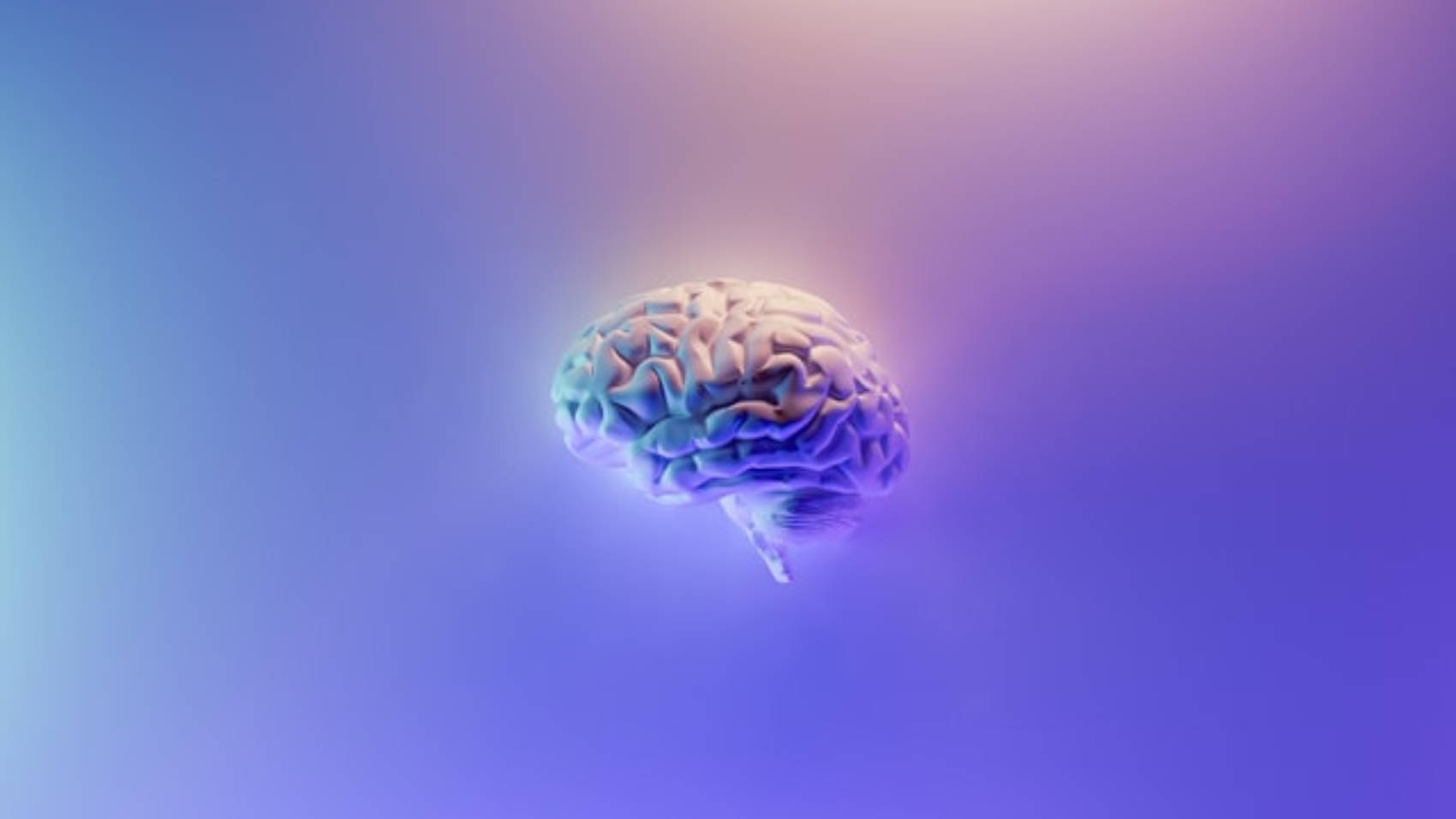 mental health 桌布 壁紙 — 一個發光的人類大腦漂浮在藍色和紫色的柔和漸變背景上。