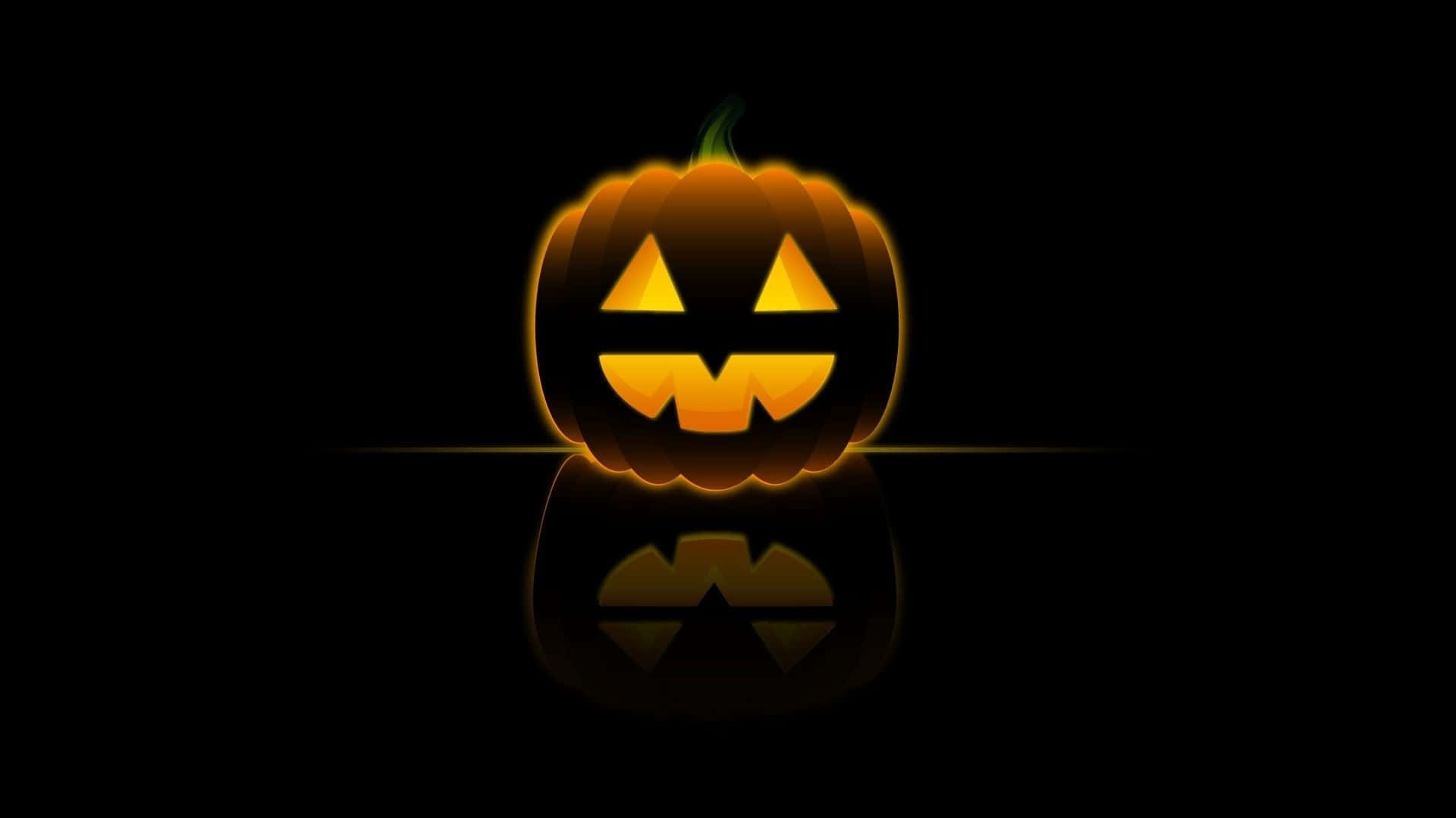 Halloween Laptop 桌布 壁紙 — 一個發光的傑克南瓜燈，帶著兇惡的笑容，在黑色背景和下方的反光表面上投射出溫暖的橙色光芒。